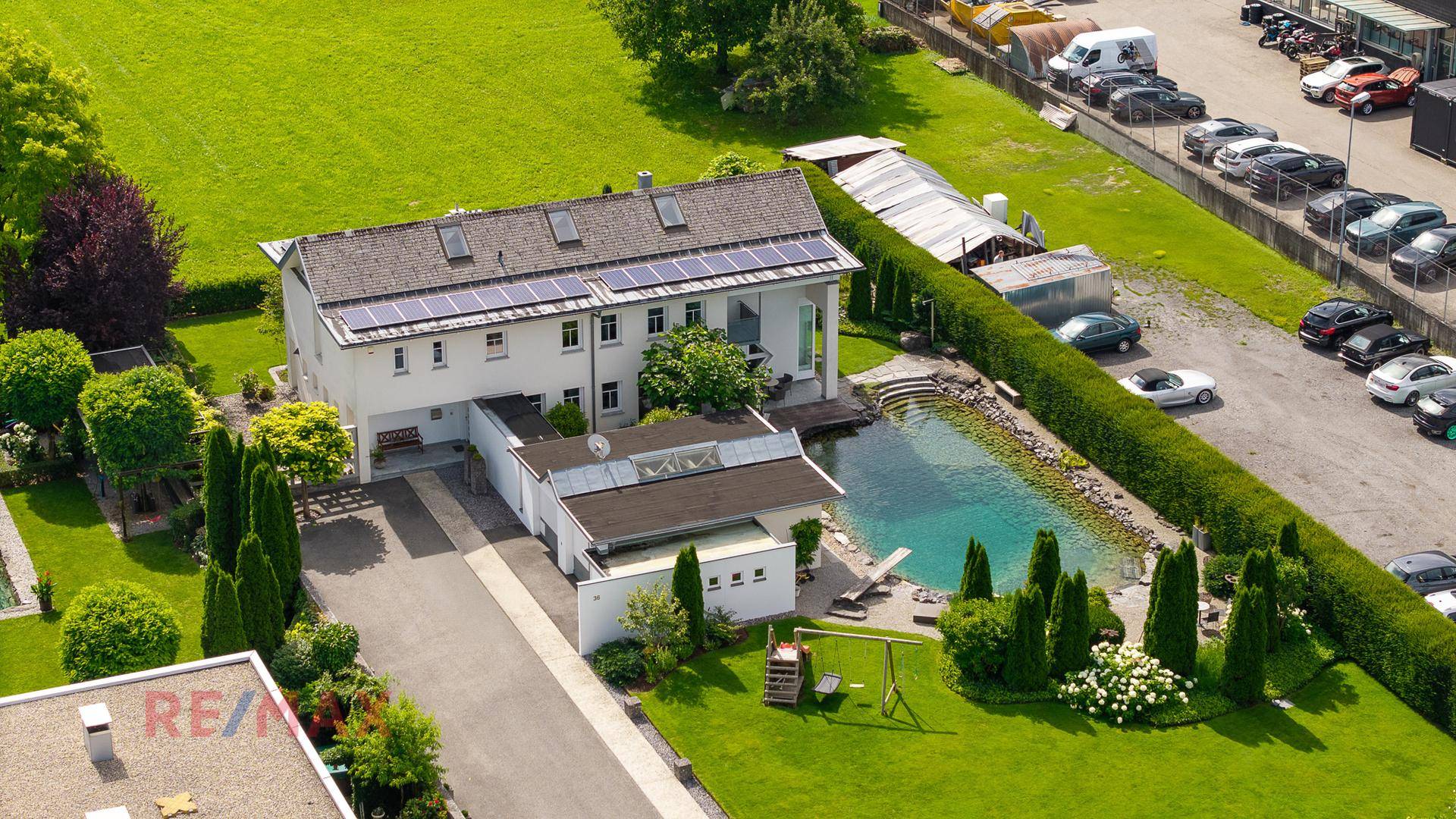 Luftaufnahme des Anwesens mit Wohnhaus, Naturbadeteich und großem Gartenbereich.