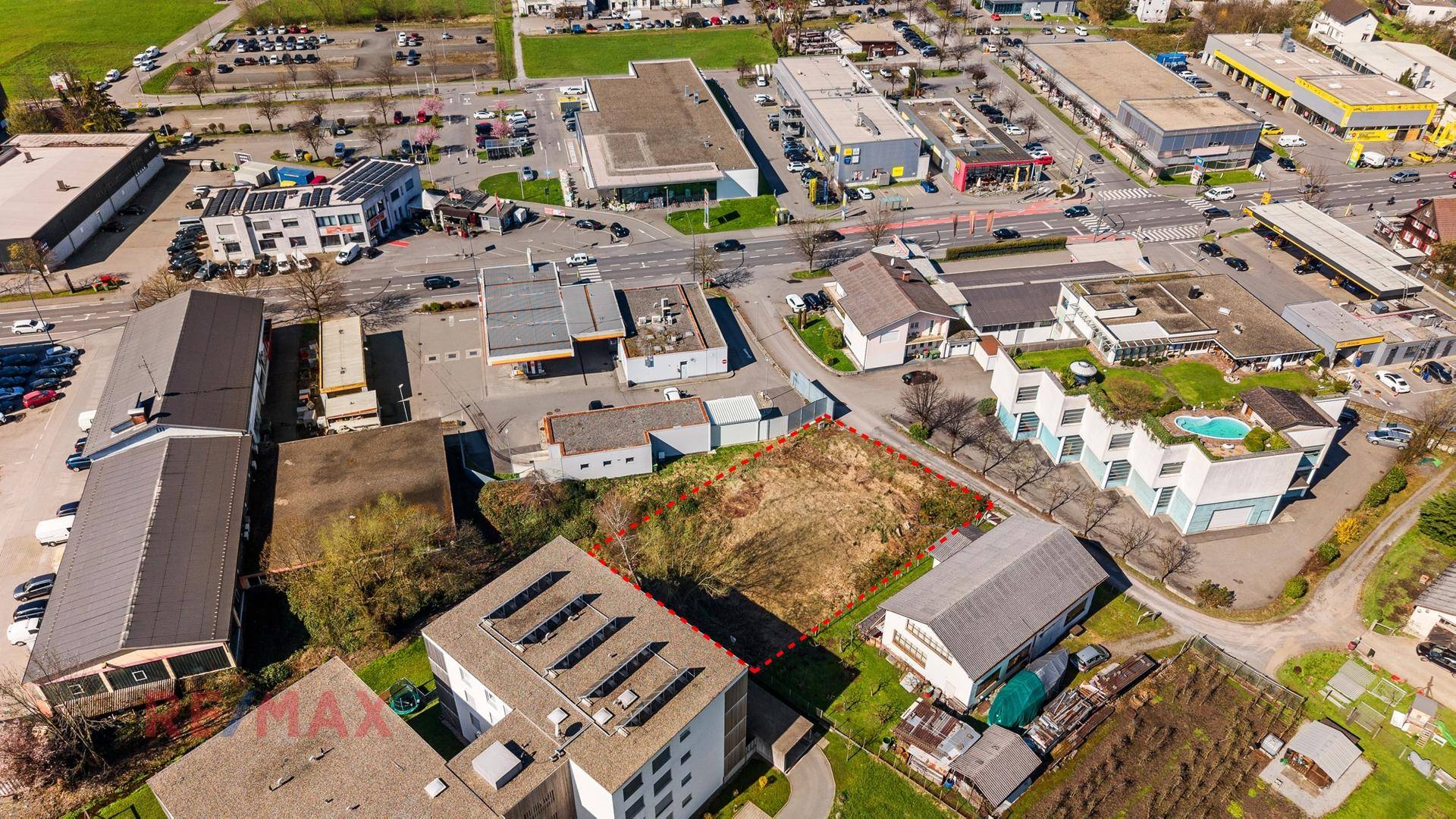 Detaillierte Luftaufnahme des Grundstücks, umgeben von verschiedenen Gebäuden und Parkplätzen.