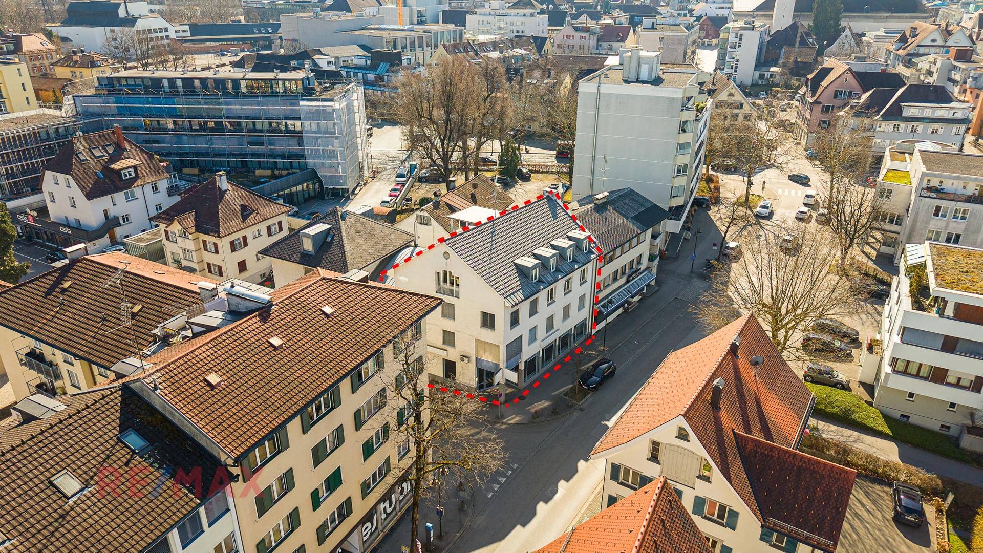 Luftaufnahme der städtischen Umgebung mit dem markierten Gebäude und umliegenden Dächern.