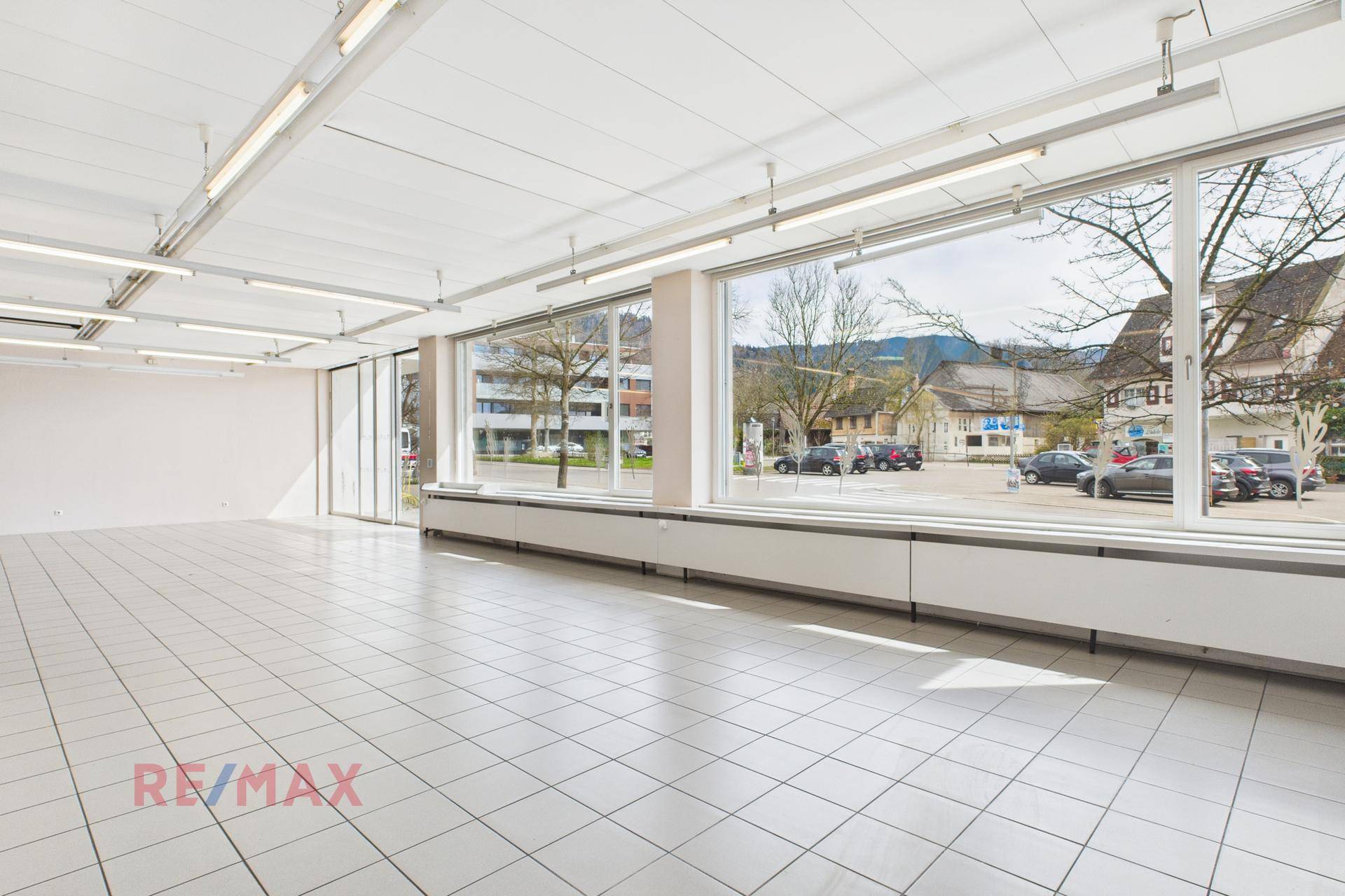 Heller Verkaufsraum mit großen Schaufenstern, die viel Tageslicht hereinlassen und eine weite Sicht bieten.