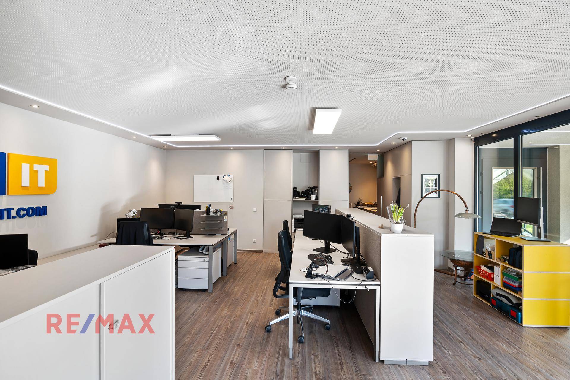 Geräumiges Büro mit modernen Arbeitsplätzen, integrierten Schränken und heller Beleuchtung.