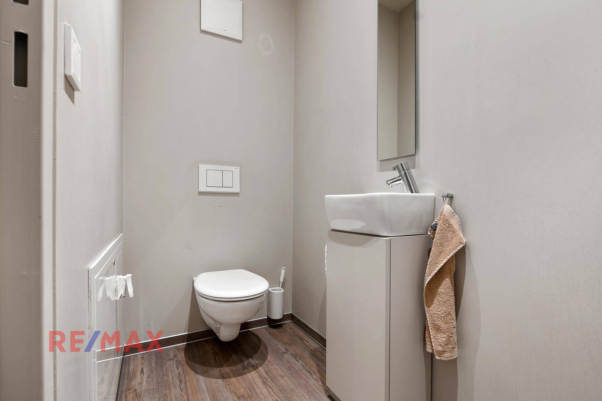 Modernes Gäste-WC mit wandhängender Toilette und stilvollem Waschbecken.