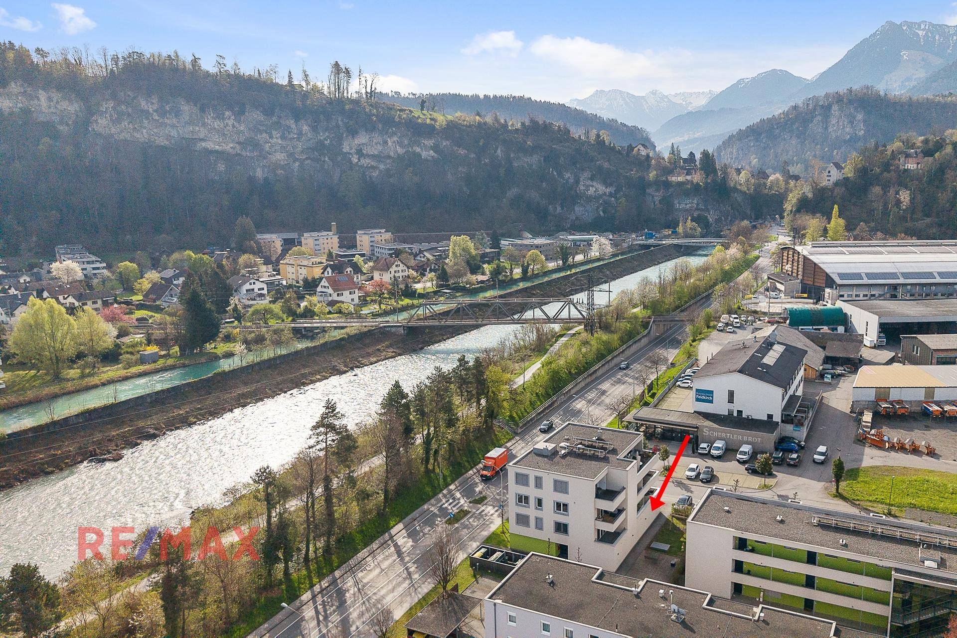 Weitläufige Luftaufnahme des Gebäudes in einer malerischen Landschaft mit Fluss und Brücke.