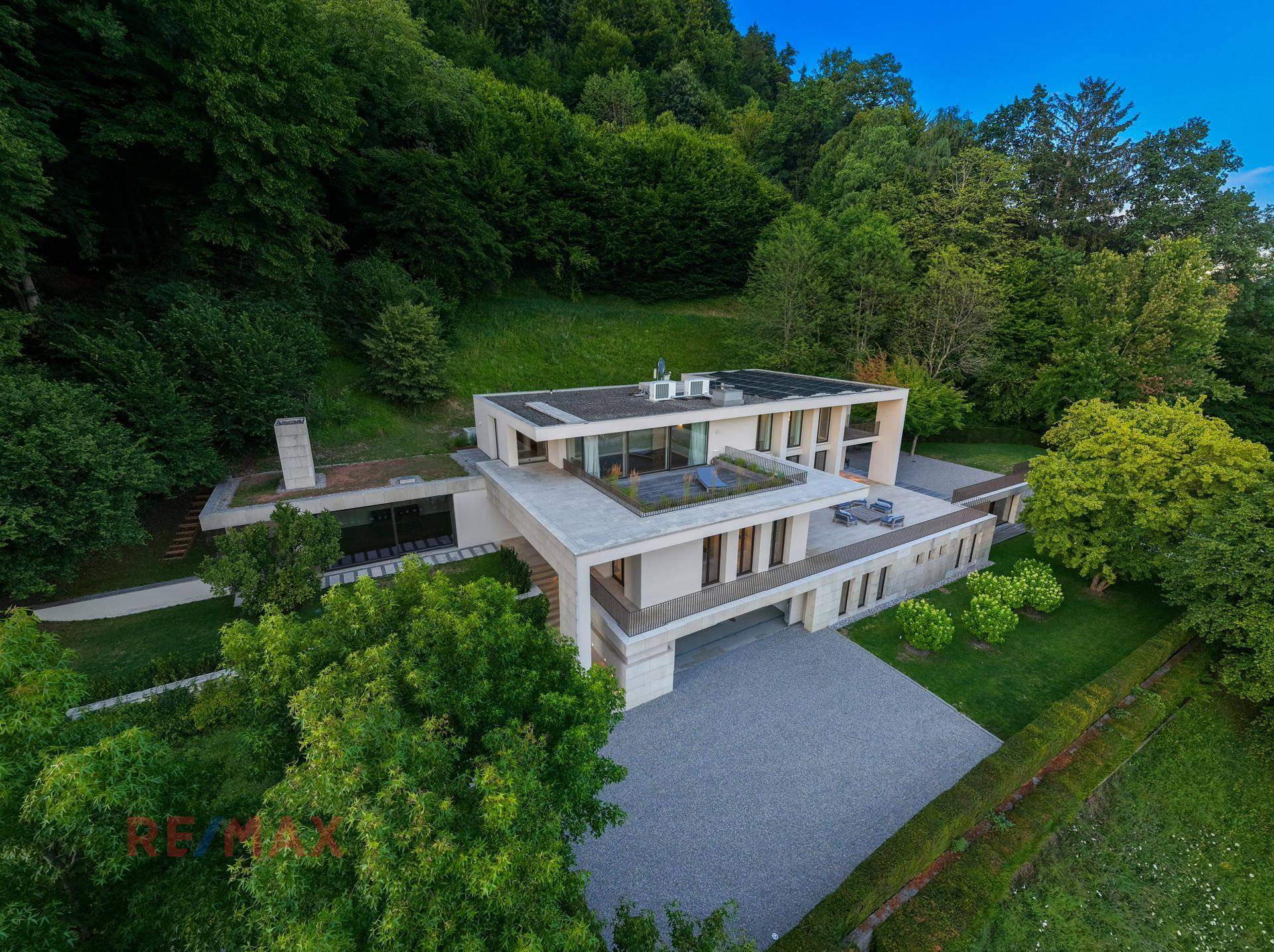 Beeindruckende Luftaufnahme der modernen Villa mit Flachdach und weitläufigen Außenbereichen.