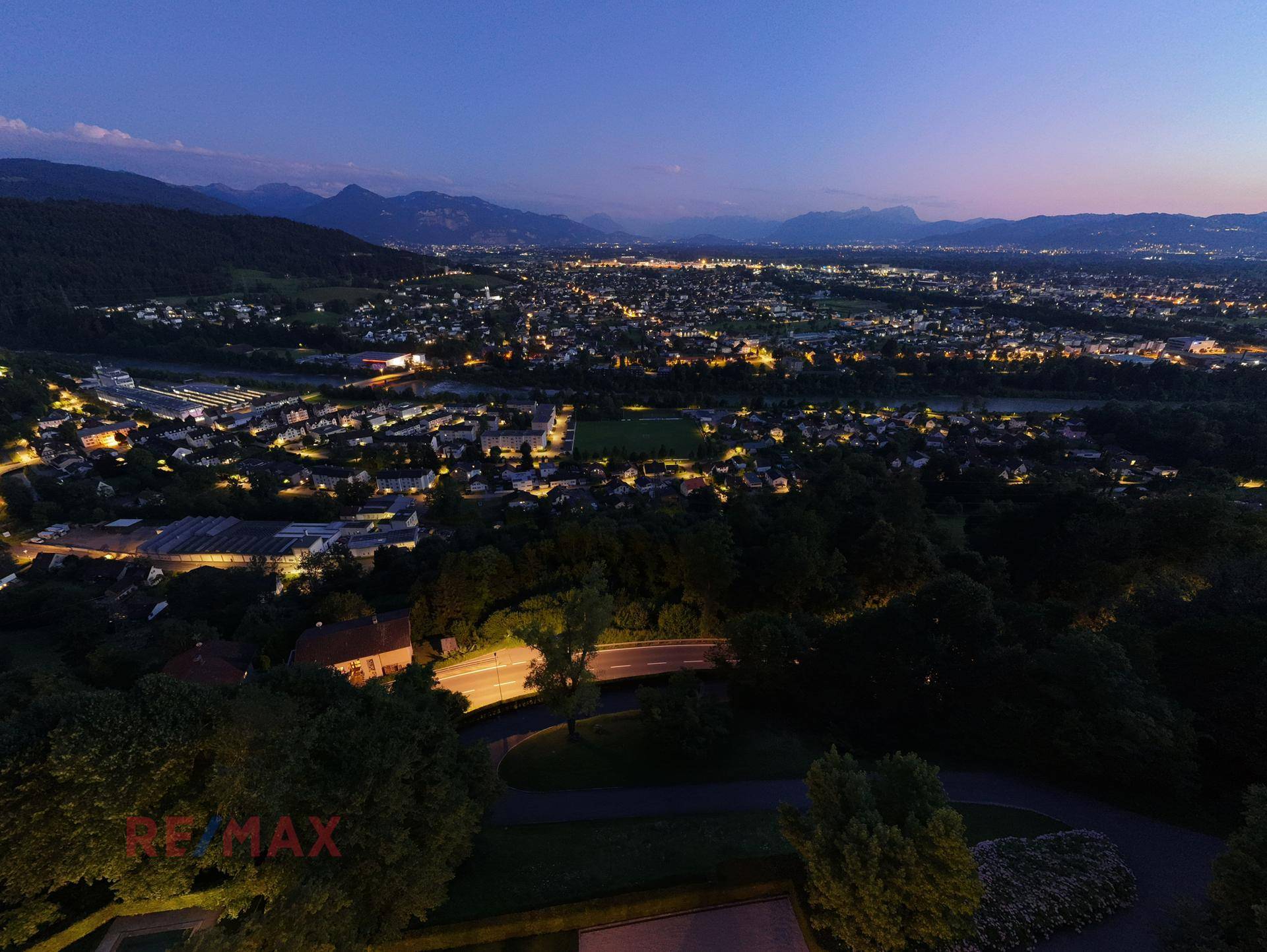 Faszinierender Nachtblick über die beleuchtete Stadt und die dunklen Umrisse der Berge.