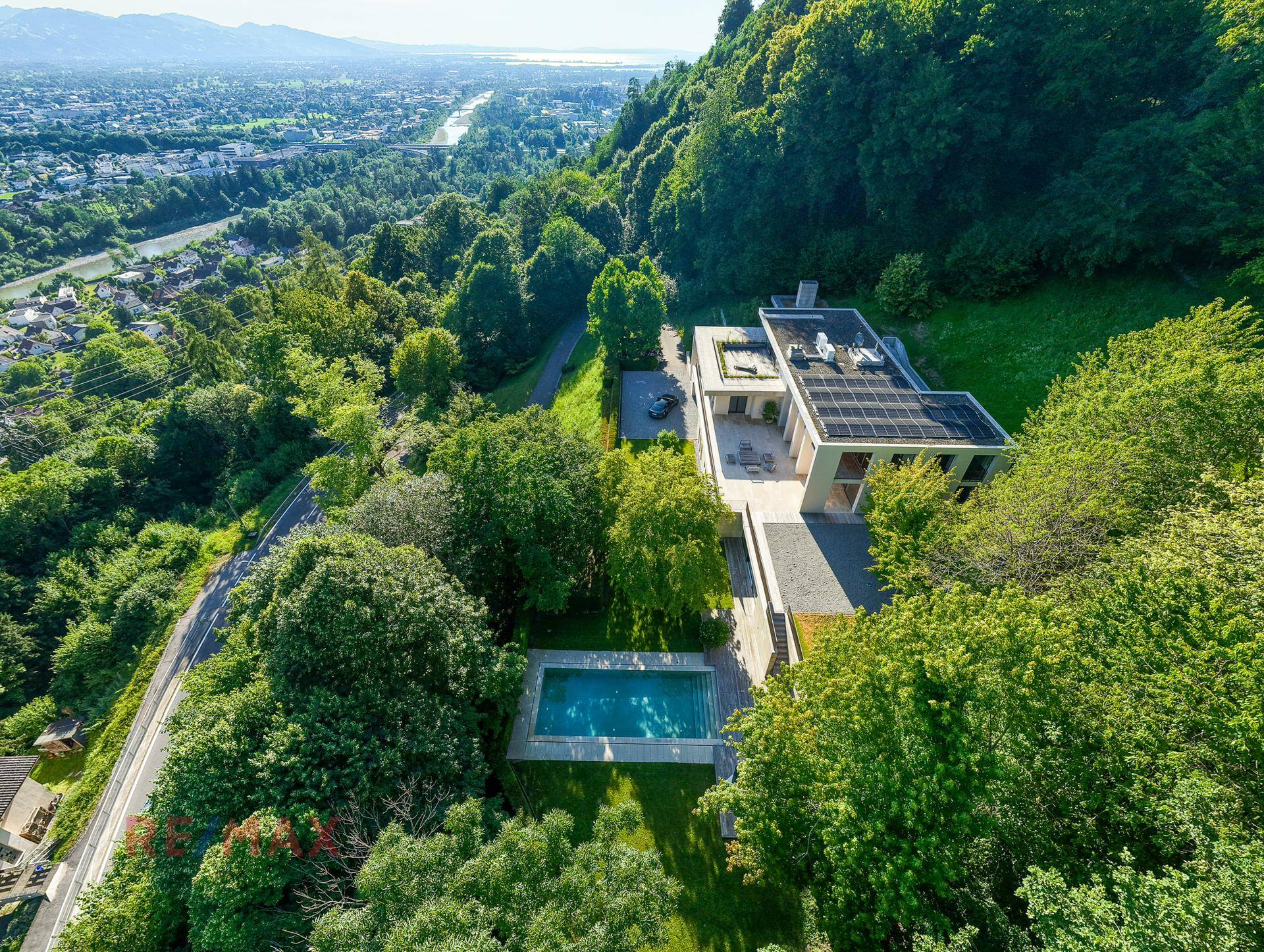 Luftaufnahme der luxuriösen Villa mit großem Pool, umgeben von üppiger Natur und Weitblick.