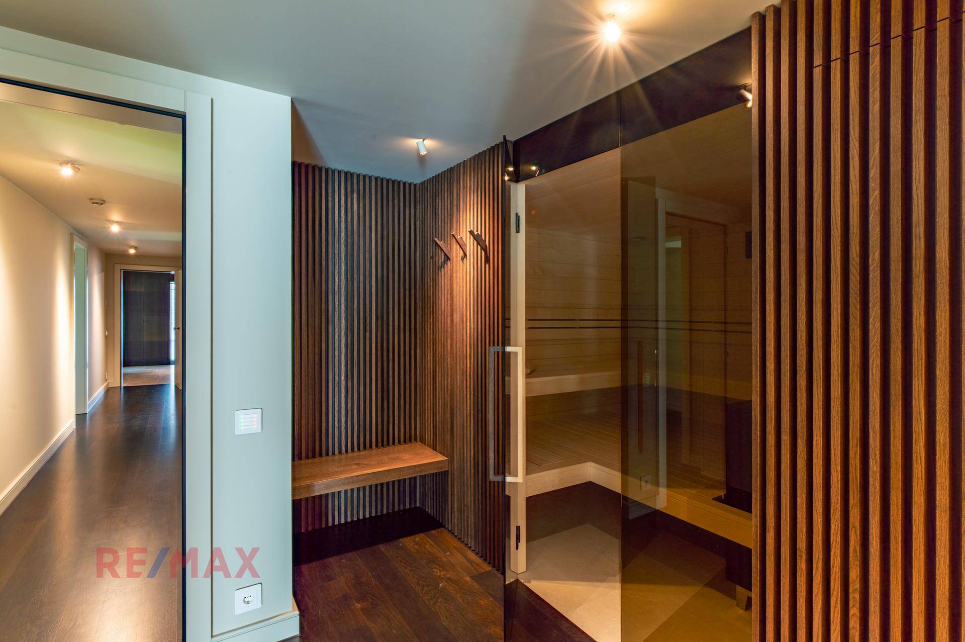 Eingangsbereich zu einem Wellnessbereich mit Holzbänken und einer modernen Sauna.