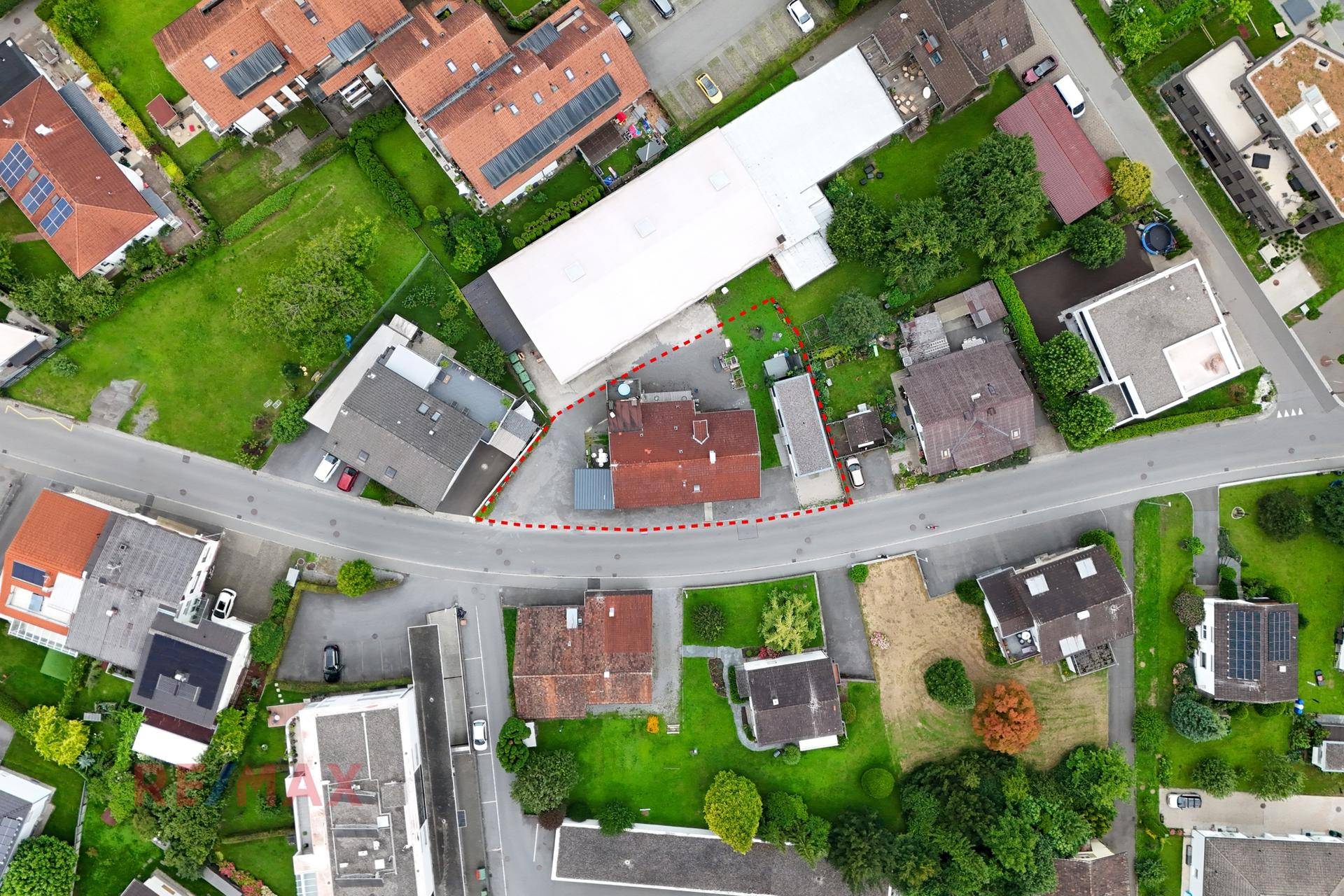 Luftaufnahme des Grundstücks mit umliegenden Gebäuden, Straßen und viel Grünfläche.