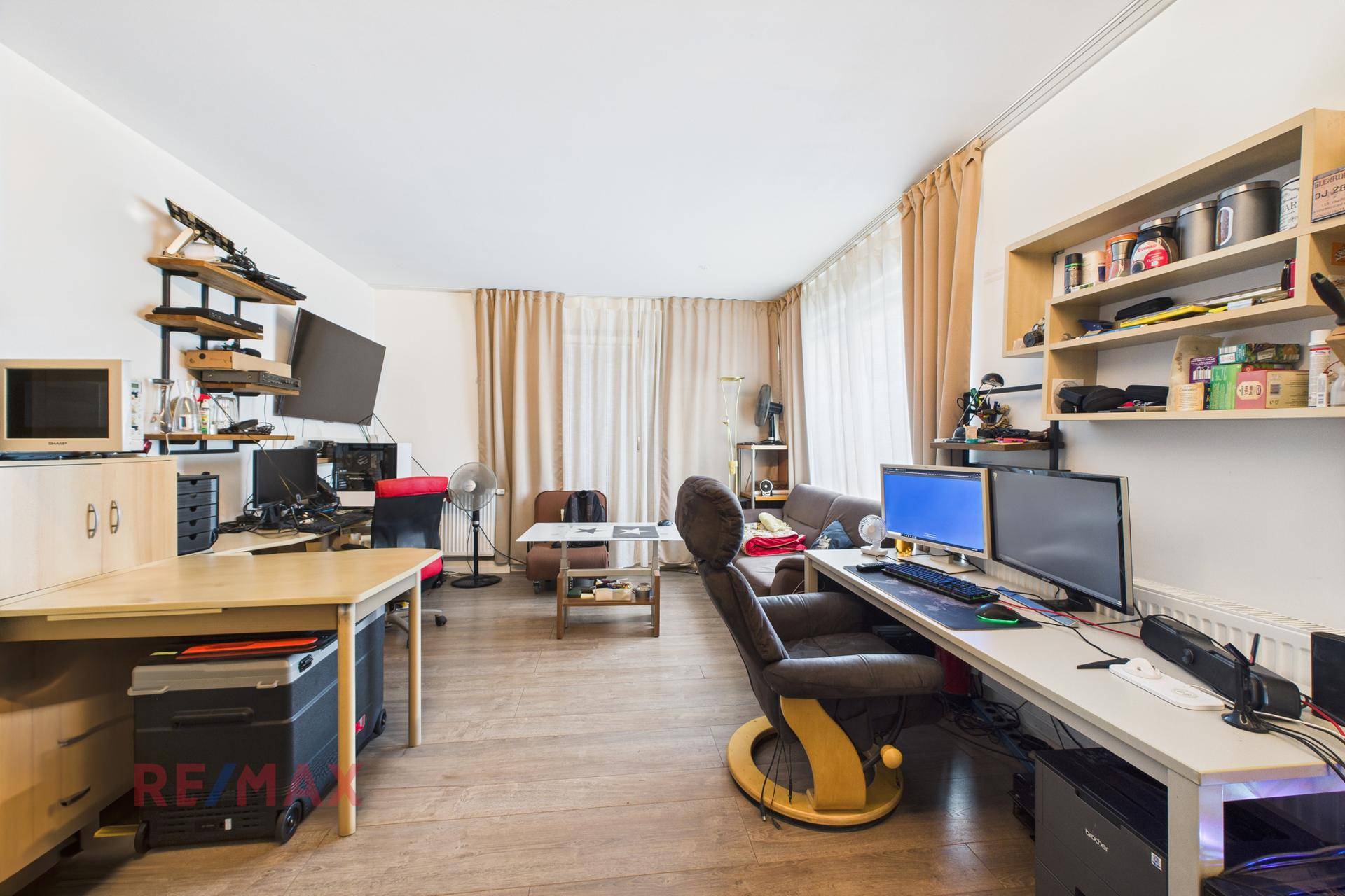 Geräumiger Arbeitsbereich mit mehreren Schreibtischen, Computern und Parkettboden.