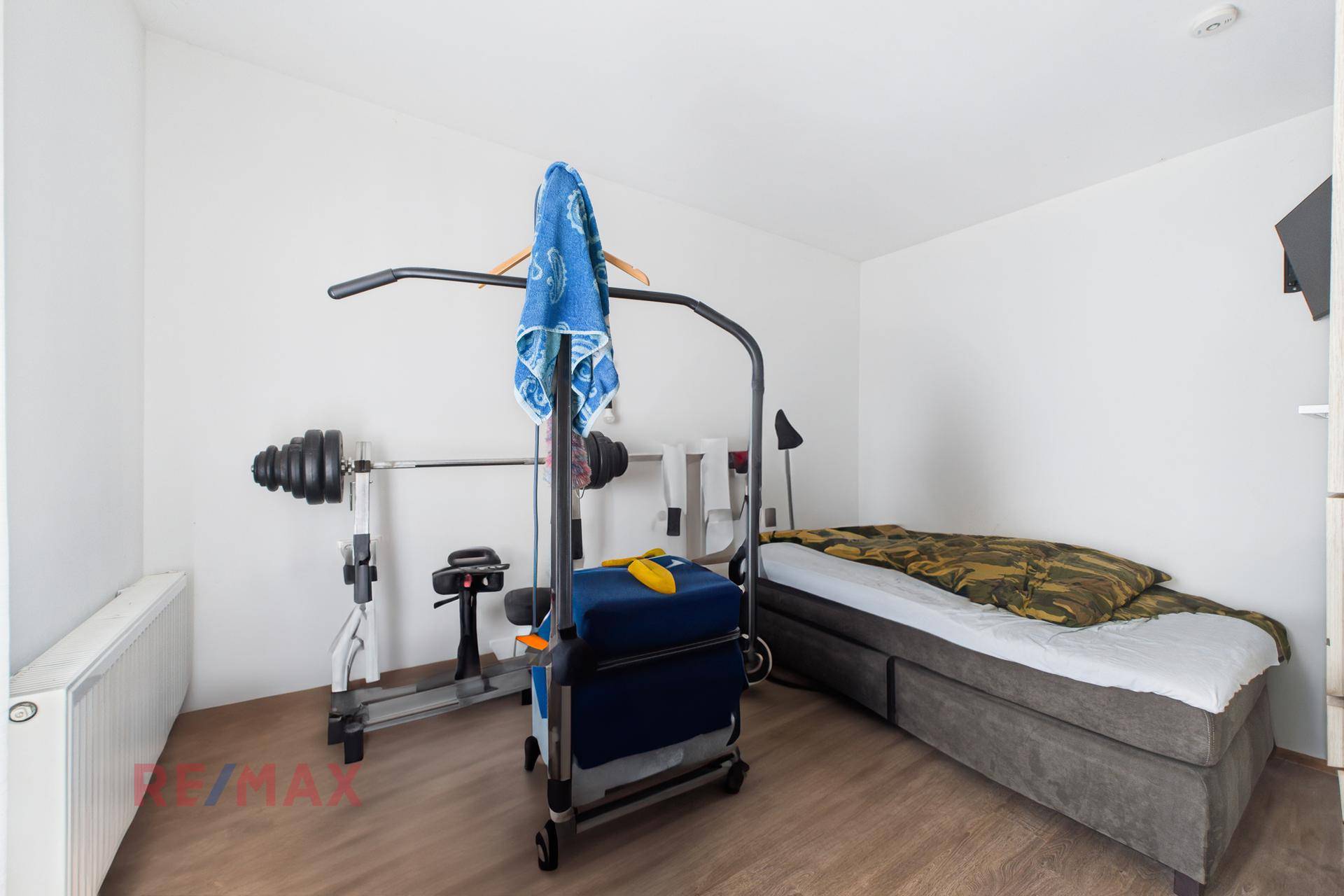 Schlafzimmer mit Bett und Fitnessgeräten, ideal für Sportbegeisterte.
