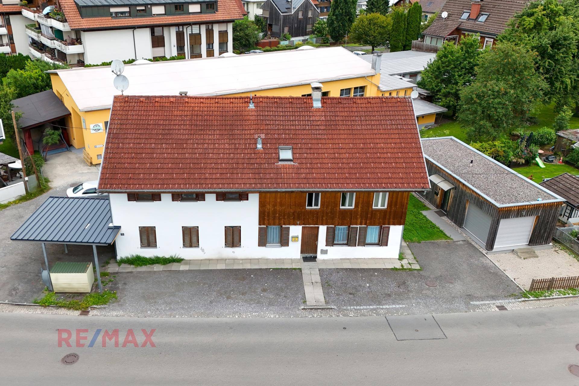 Ansicht des Wohnhauses mit Carport und separatem Garagengebäude.