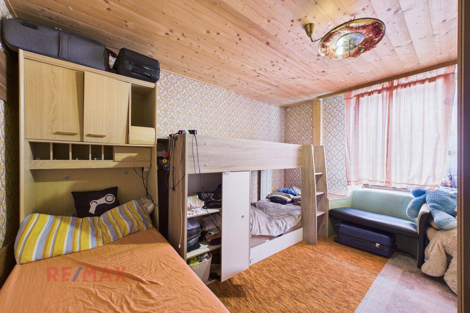 Geräumiges Kinderzimmer mit Etagenbett, Einzelbett und Sofa, ideal für mehrere Kinder.