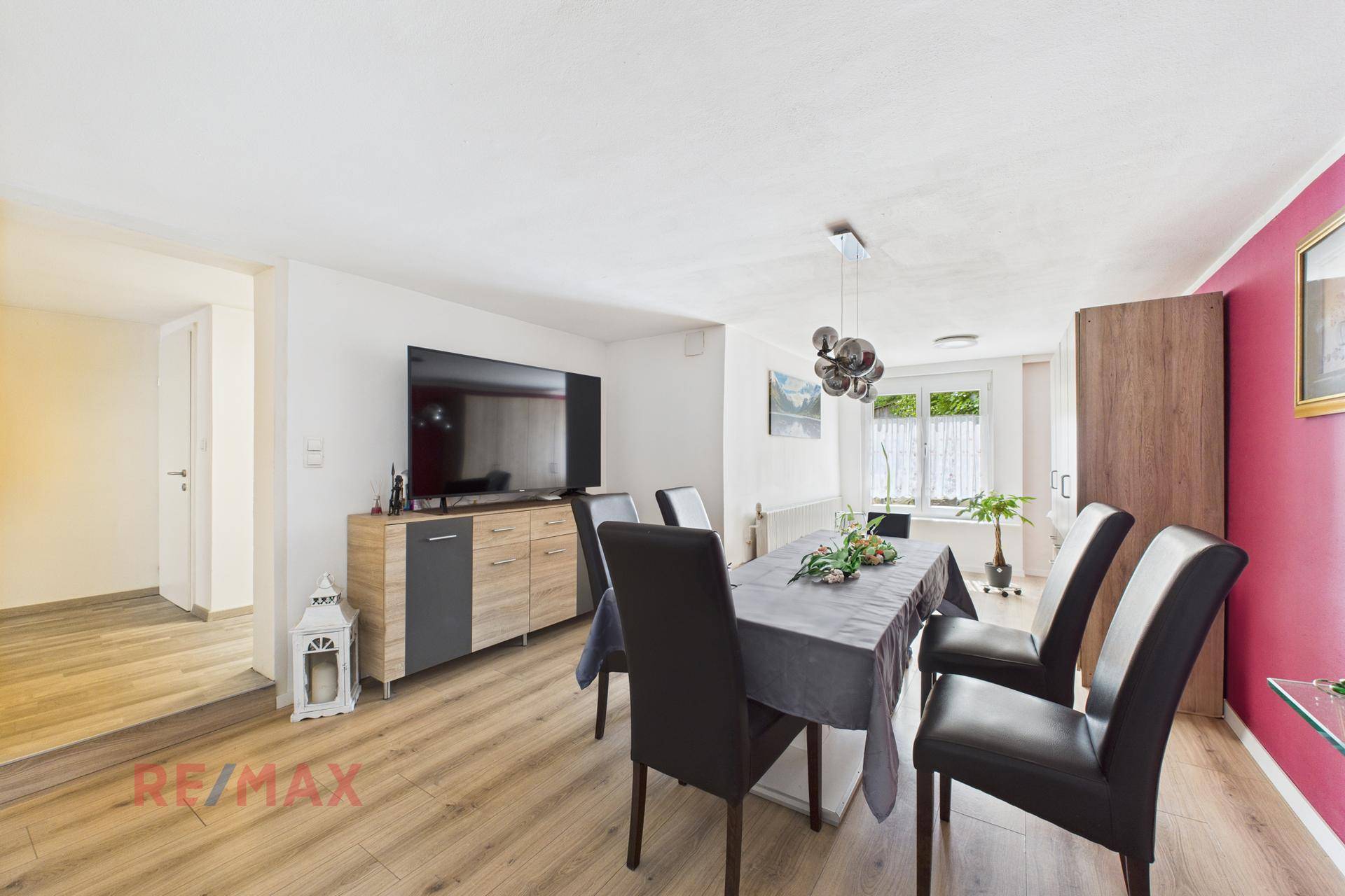 Geräumiges Esszimmer mit Esstisch, Sideboard und Blick in den Flur.