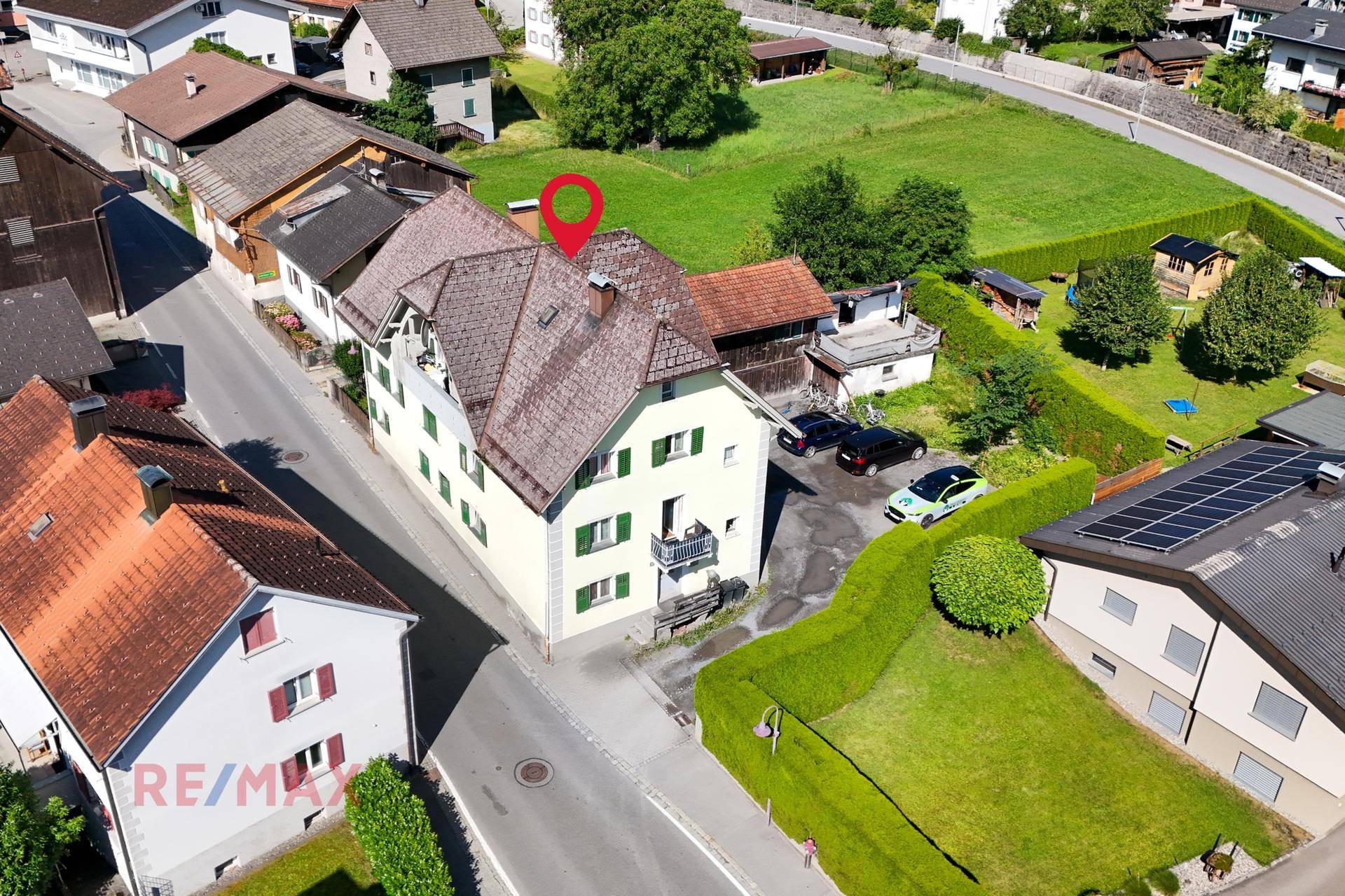 Übersicht des Anwesens mit angrenzenden Grünflächen und Parkplätzen in ländlicher Umgebung.