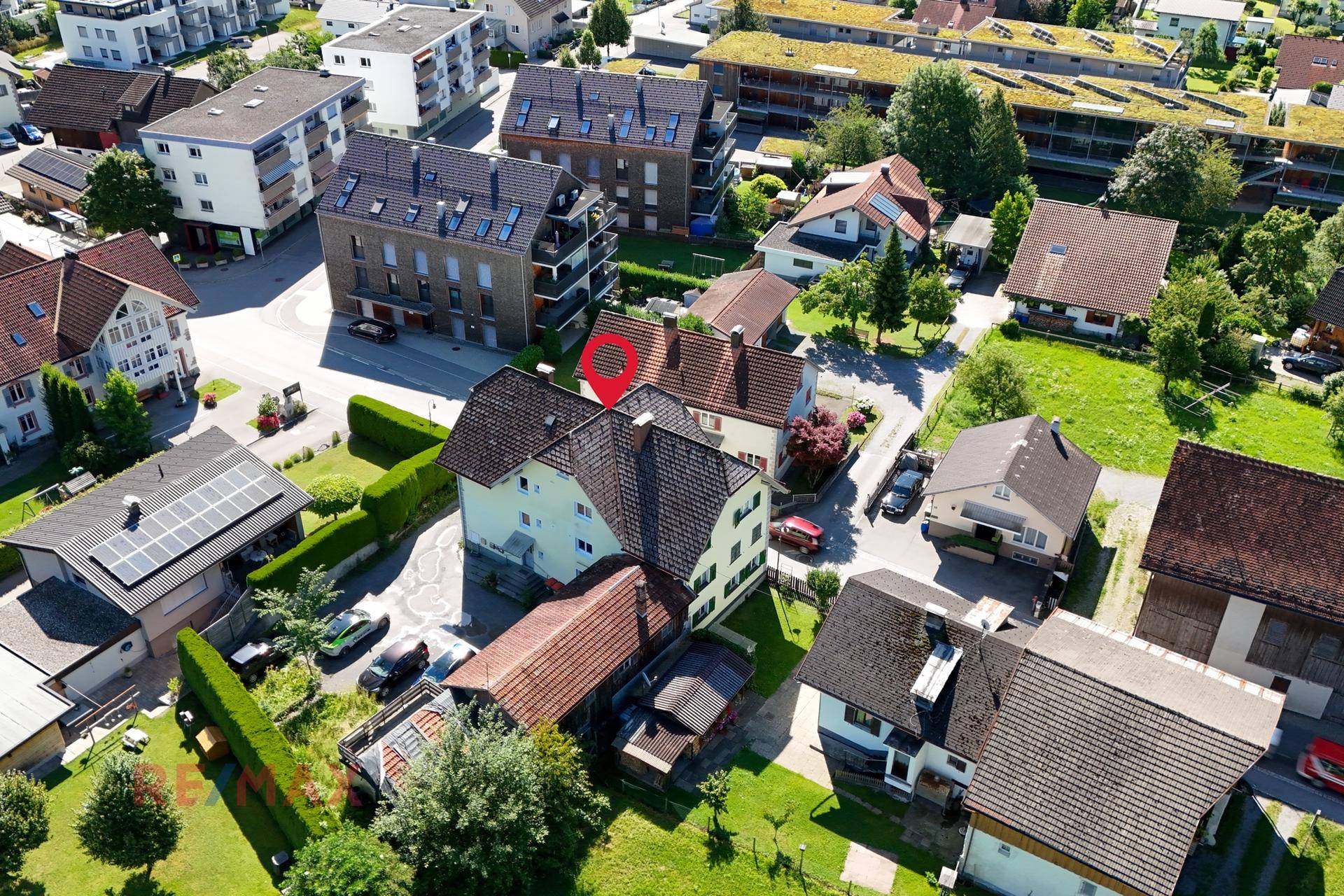 Luftaufnahme des Wohnhauses in einer Siedlung mit umliegenden Gärten und Gebäuden.