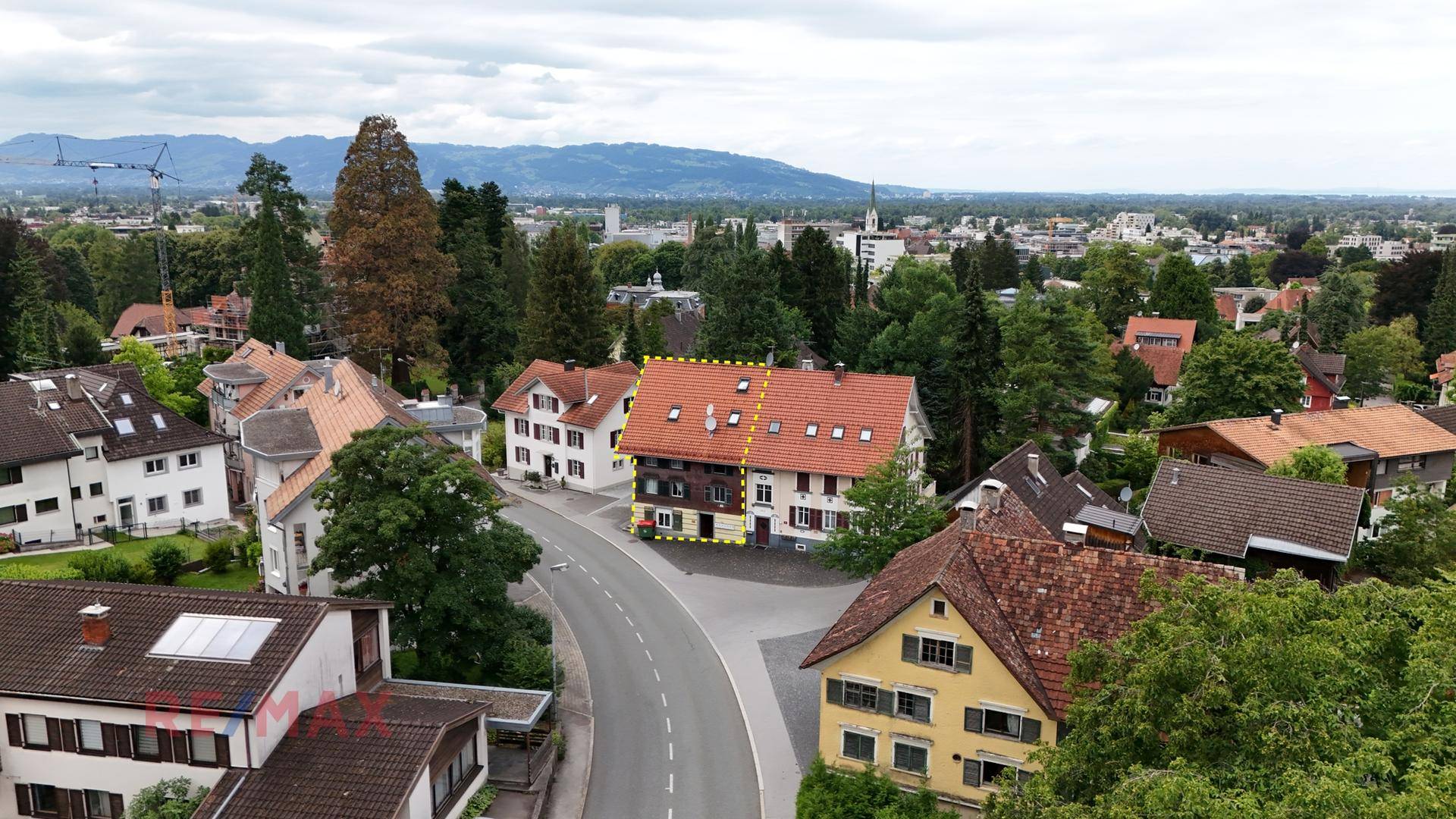 Panoramablick auf das Gebäude und die umliegende Stadtlandschaft mit Bergen im Hintergrund.