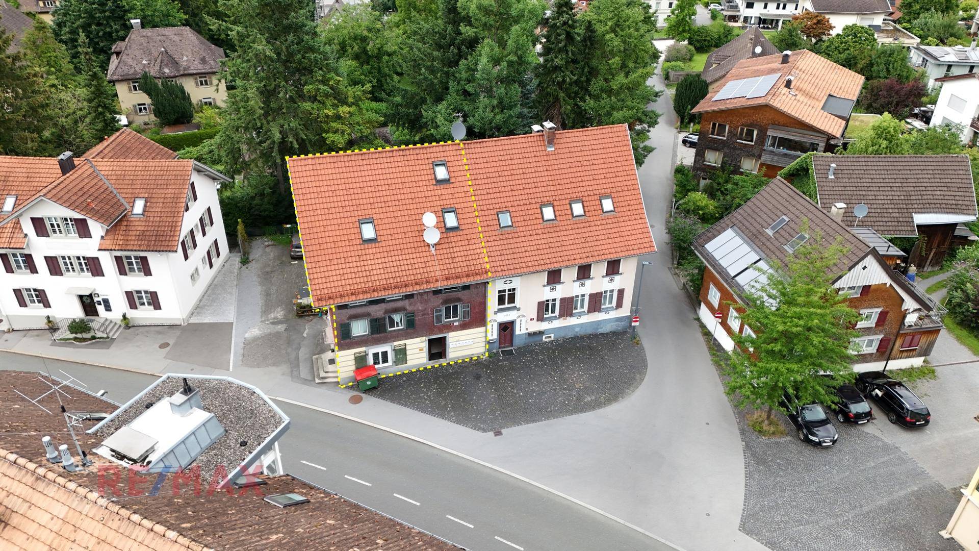 Vogelperspektive des Gebäudes mit rotem Ziegeldach und angrenzenden Grundstücken.
