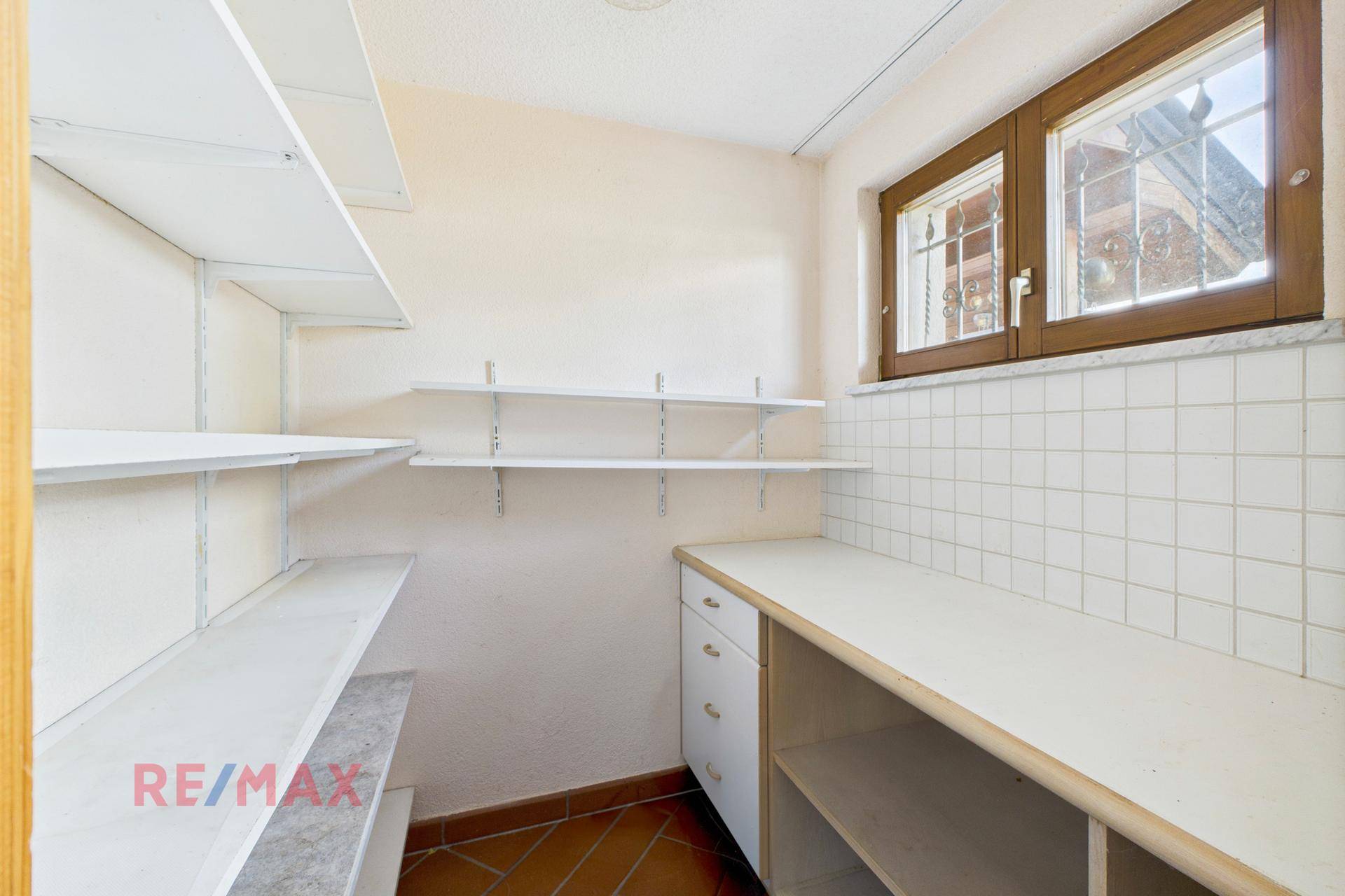 Praktischer Abstellraum mit Regalen und Fenster, bietet viel Stauraum.