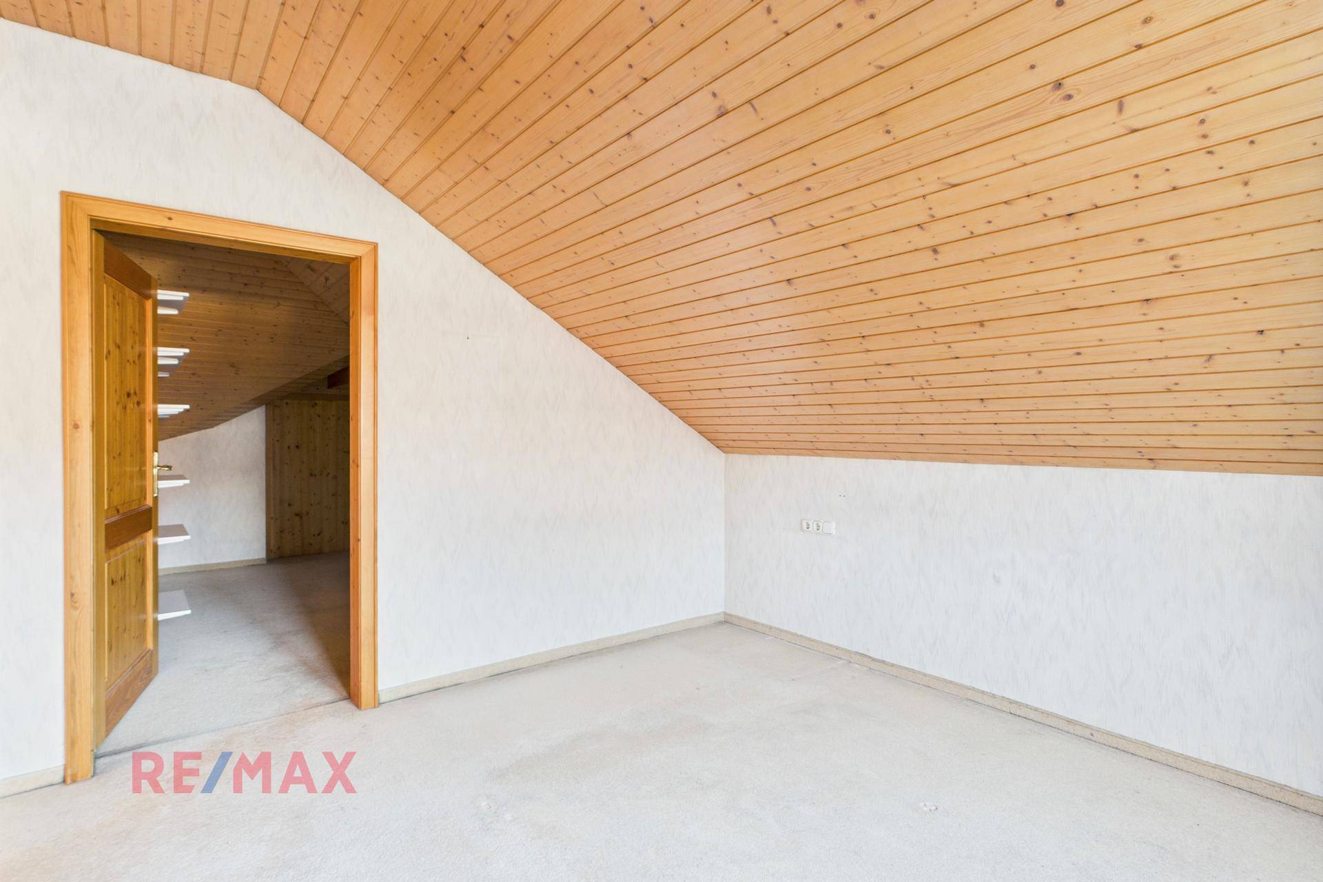 Eingangsbereich zum Dachzimmer mit Holzdecke und Teppichboden, gemütlich und hell.