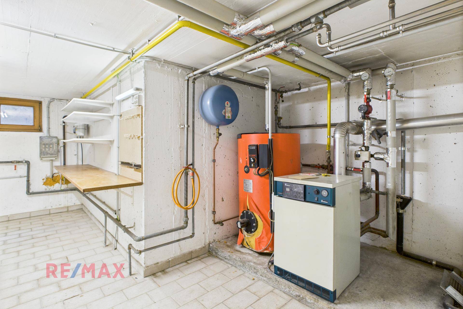 Heizungsraum im Keller mit Heizungsanlage und sichtbaren Rohren, gut organisiert.