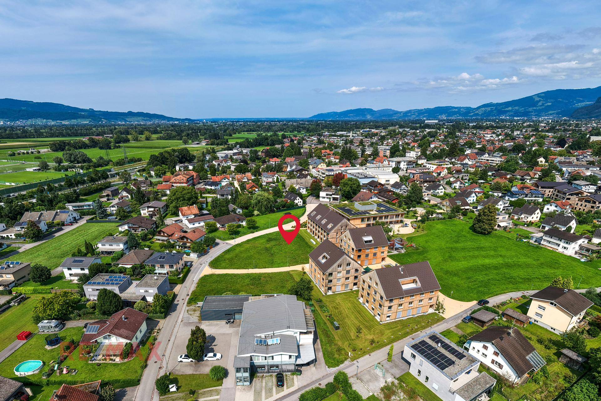 Weitläufige Luftaufnahme der ländlichen Umgebung mit Bergen im Hintergrund und markiertem Grundstück.