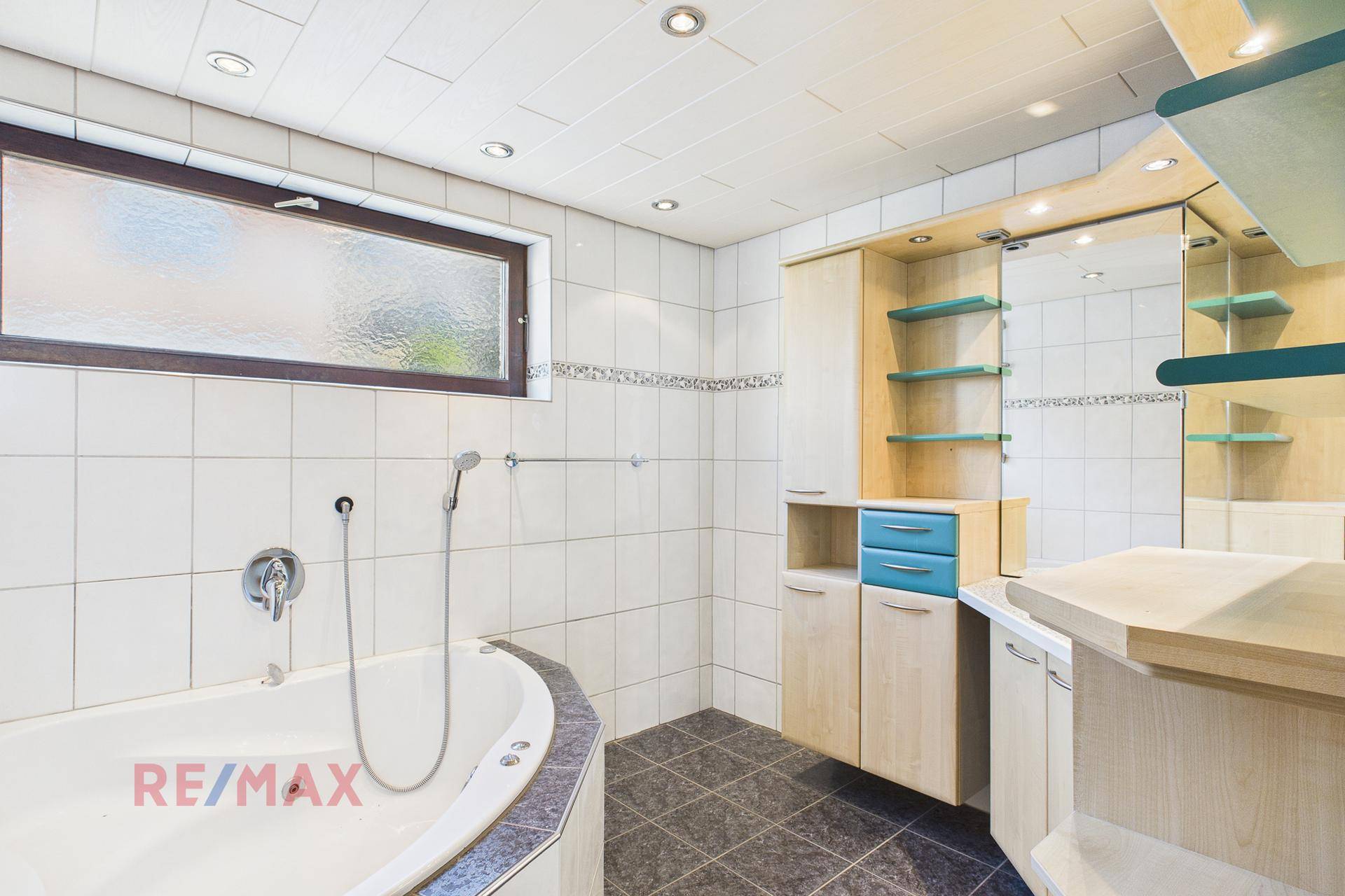 Badezimmer mit Whirlpool-Badewanne, Dusche und modernem Waschtischbereich.