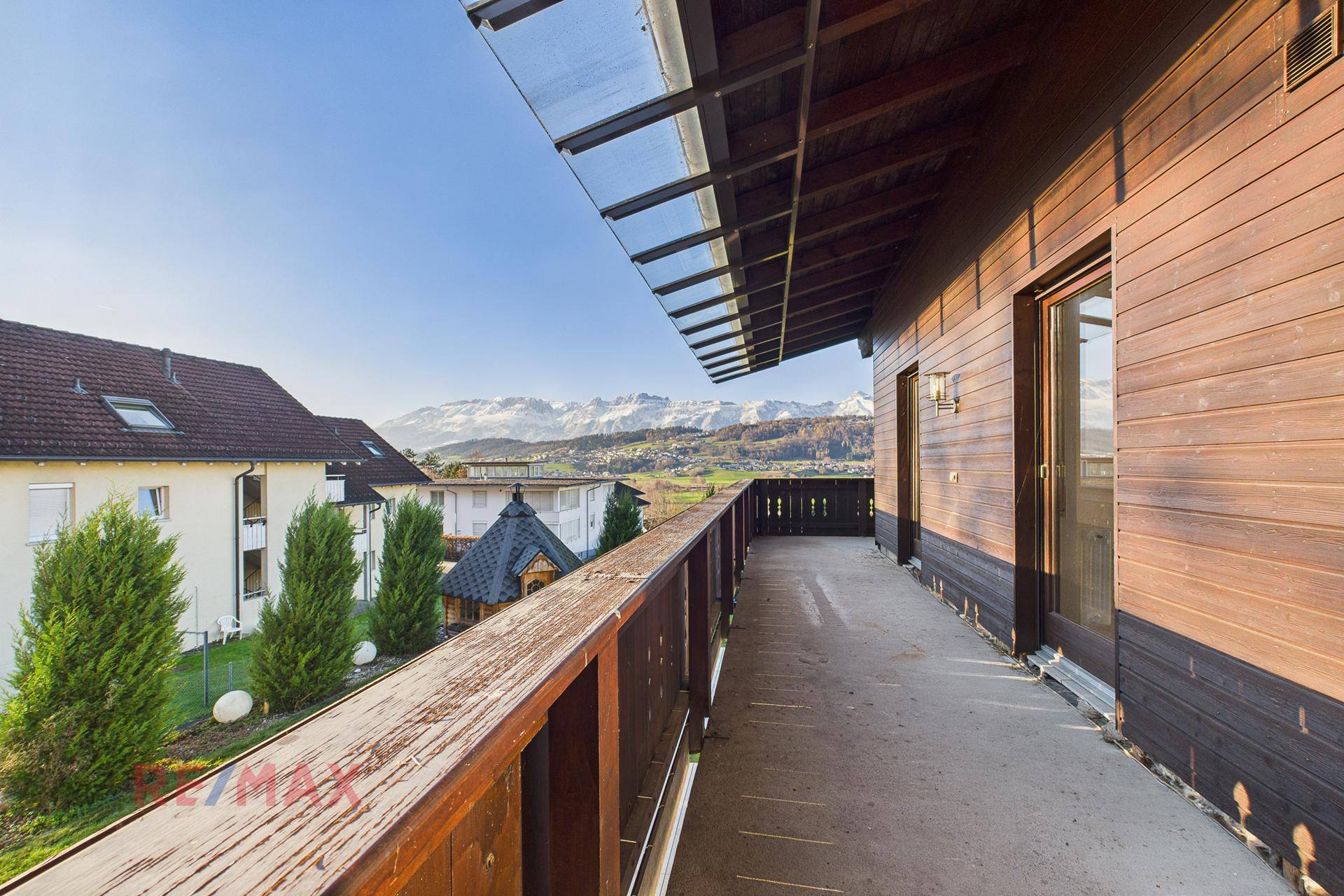 Langer Holzbalkon mit Bergblick und weitem Ausblick über die Landschaft.