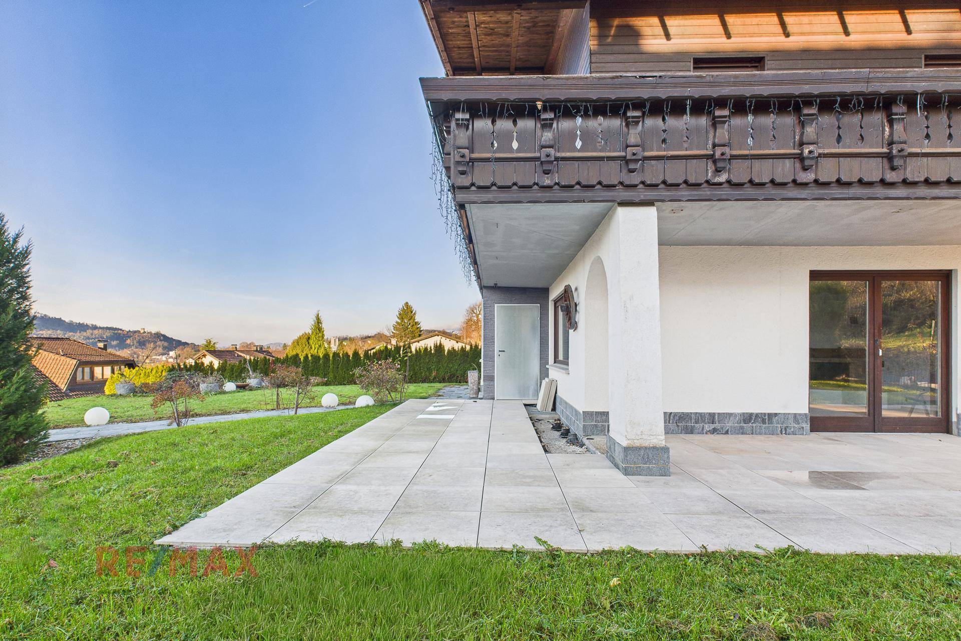 Große gepflasterte Terrasse am Haus mit Zugang zum Garten und Bergblick.