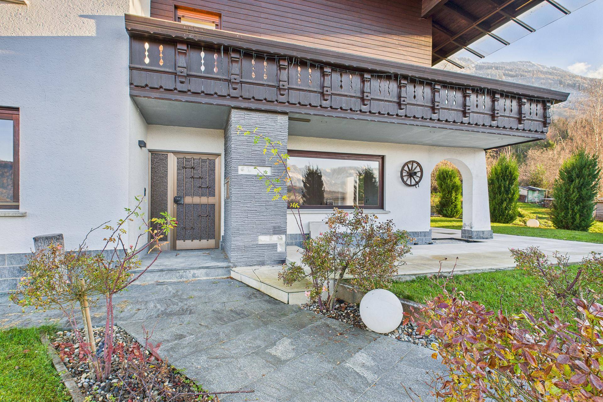 Eingangsbereich des Hauses mit Steinverkleidung und gepflegtem Vorgarten.