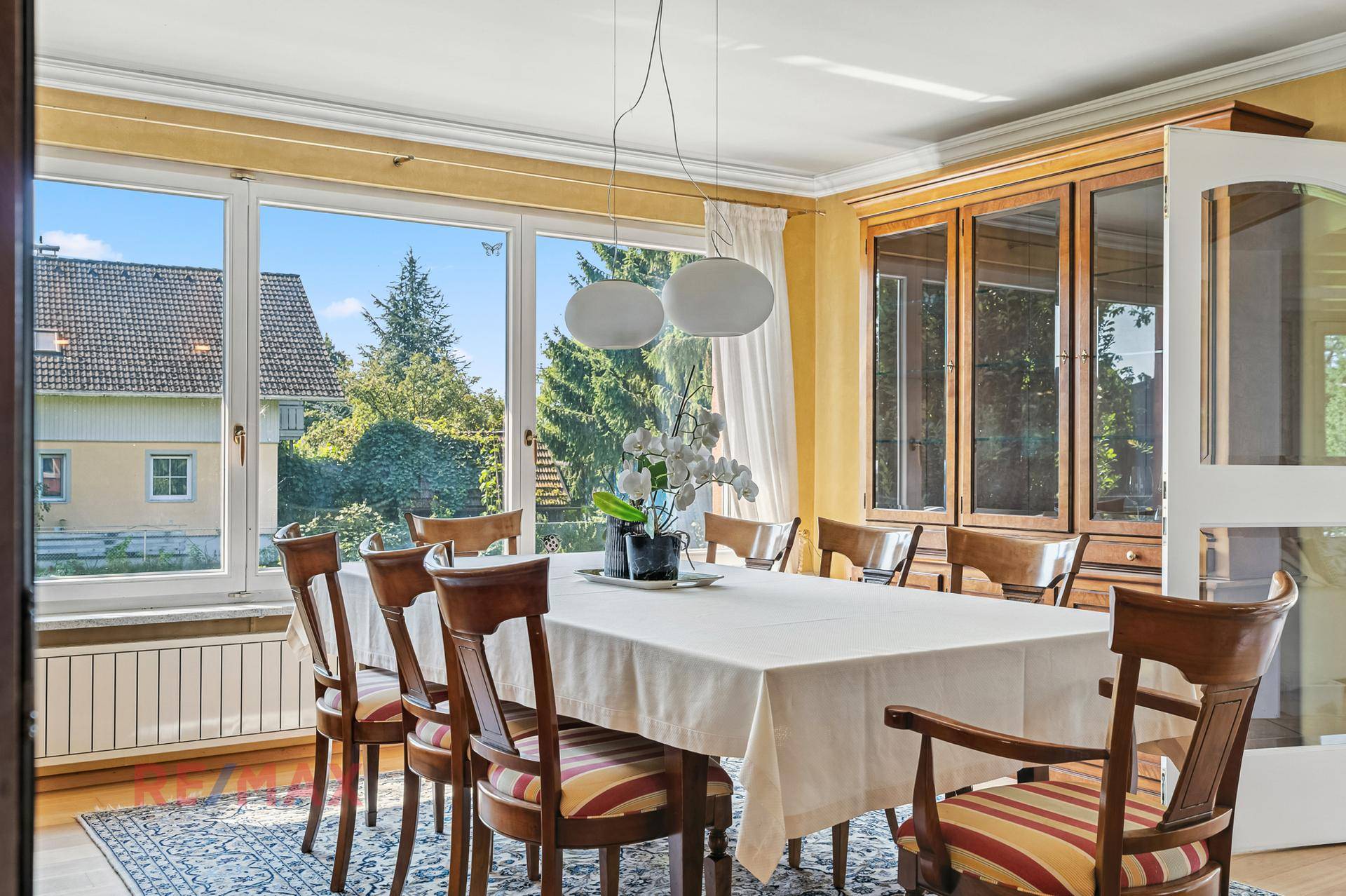 Klassischer Essbereich mit großem Holztisch, Stühlen und Blick in den Garten.