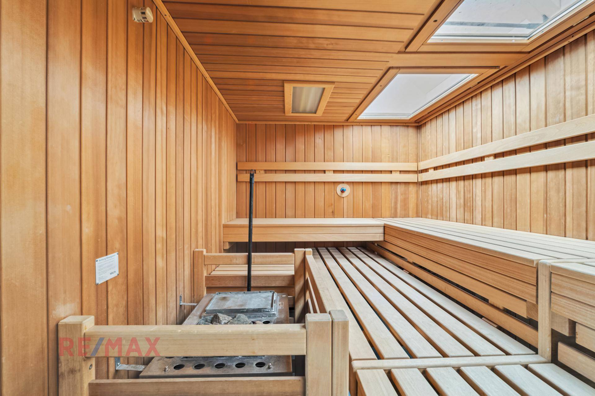 Traditionelle Holzsauna mit mehreren Bänken und Heizofen, ideal zur Entspannung.