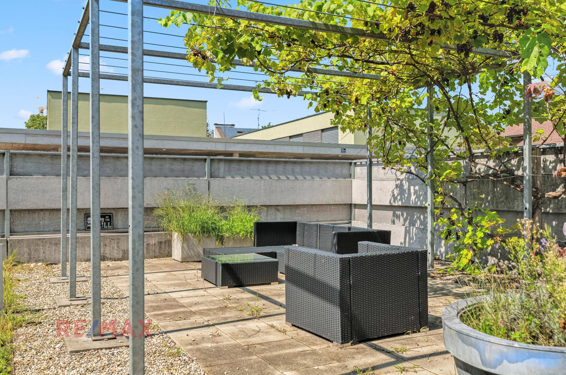 Geräumige Dachterrasse mit Pergola und Outdoor-Möbeln, ideal für Entspannung im Freien.