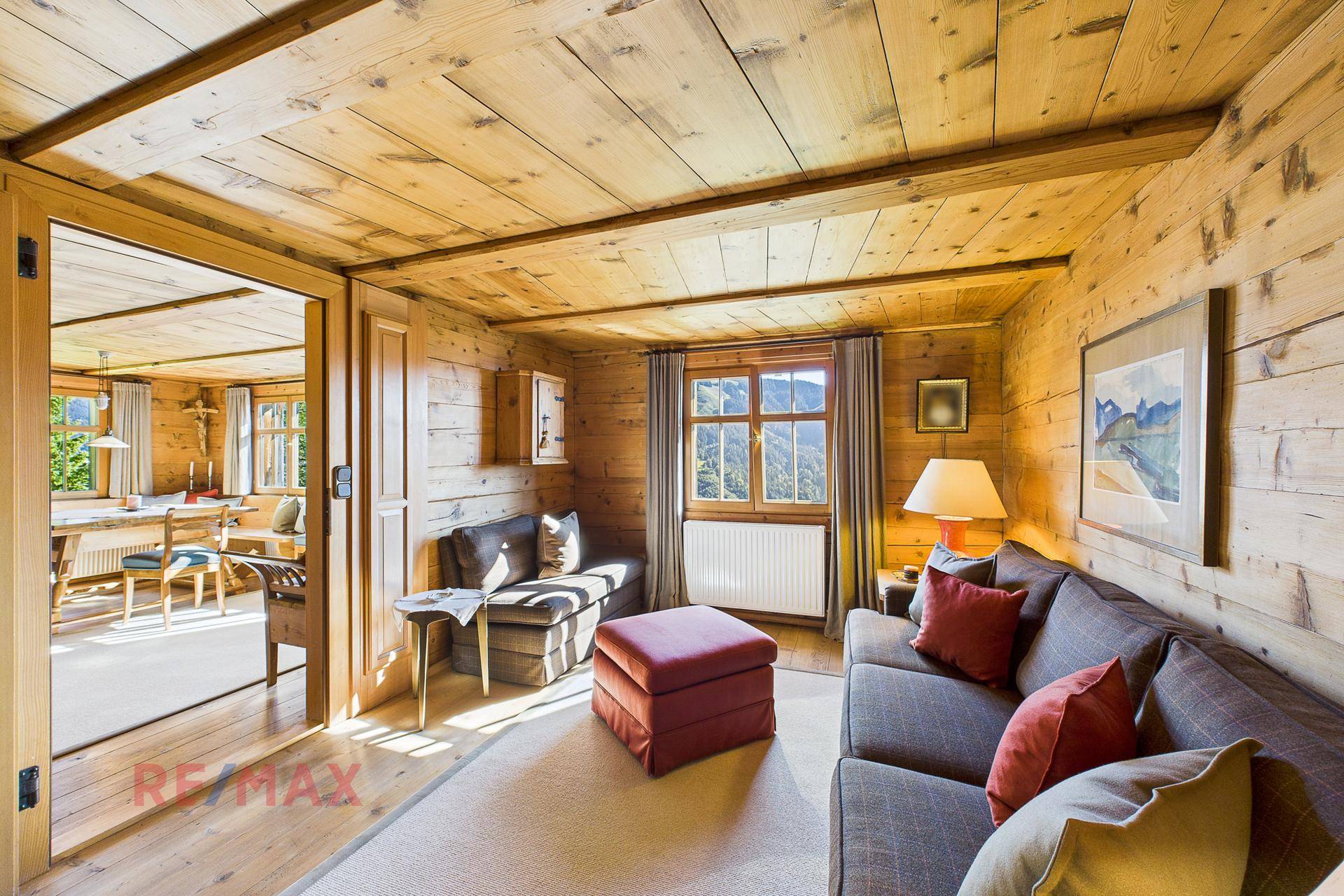 Helles Wohnzimmer mit Holzwänden und Zugang zum Essbereich, ideal für gesellige Stunden.