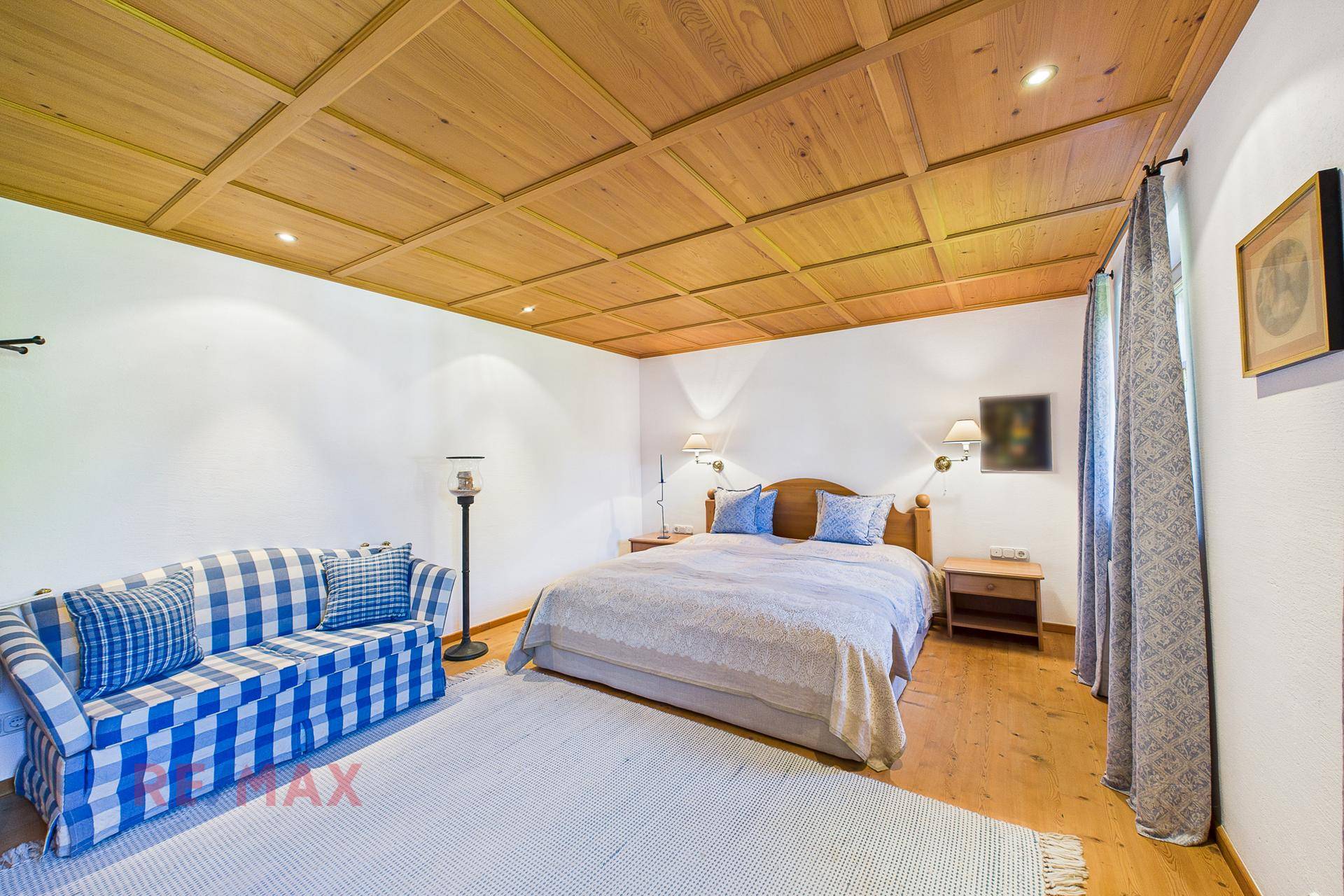 Gemütliches Schlafzimmer mit Holzkassettendecke, Doppelbett und traditioneller Einrichtung.