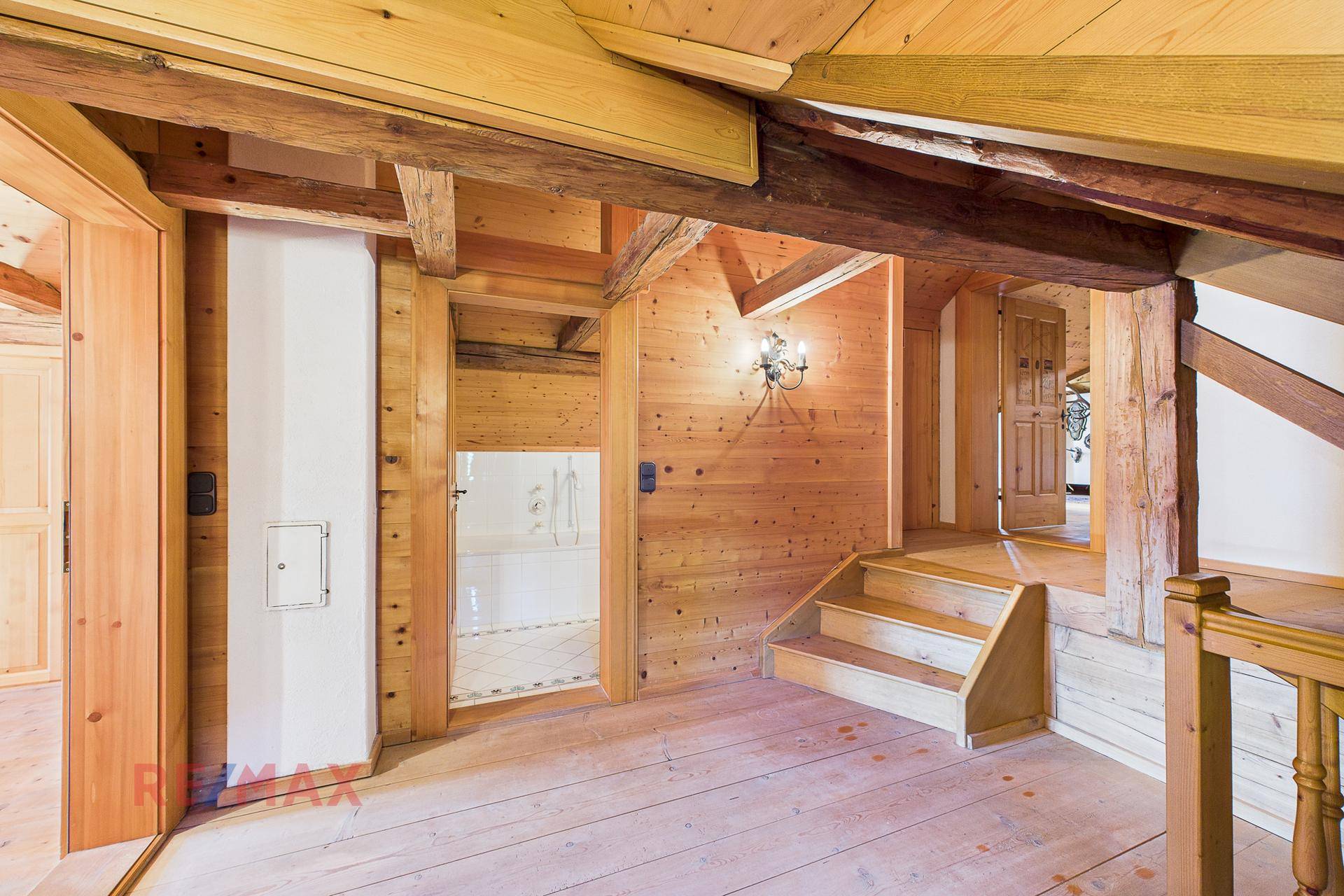 Holztreppe führt zu einem weiteren Bereich mit Holzwänden und -decken.