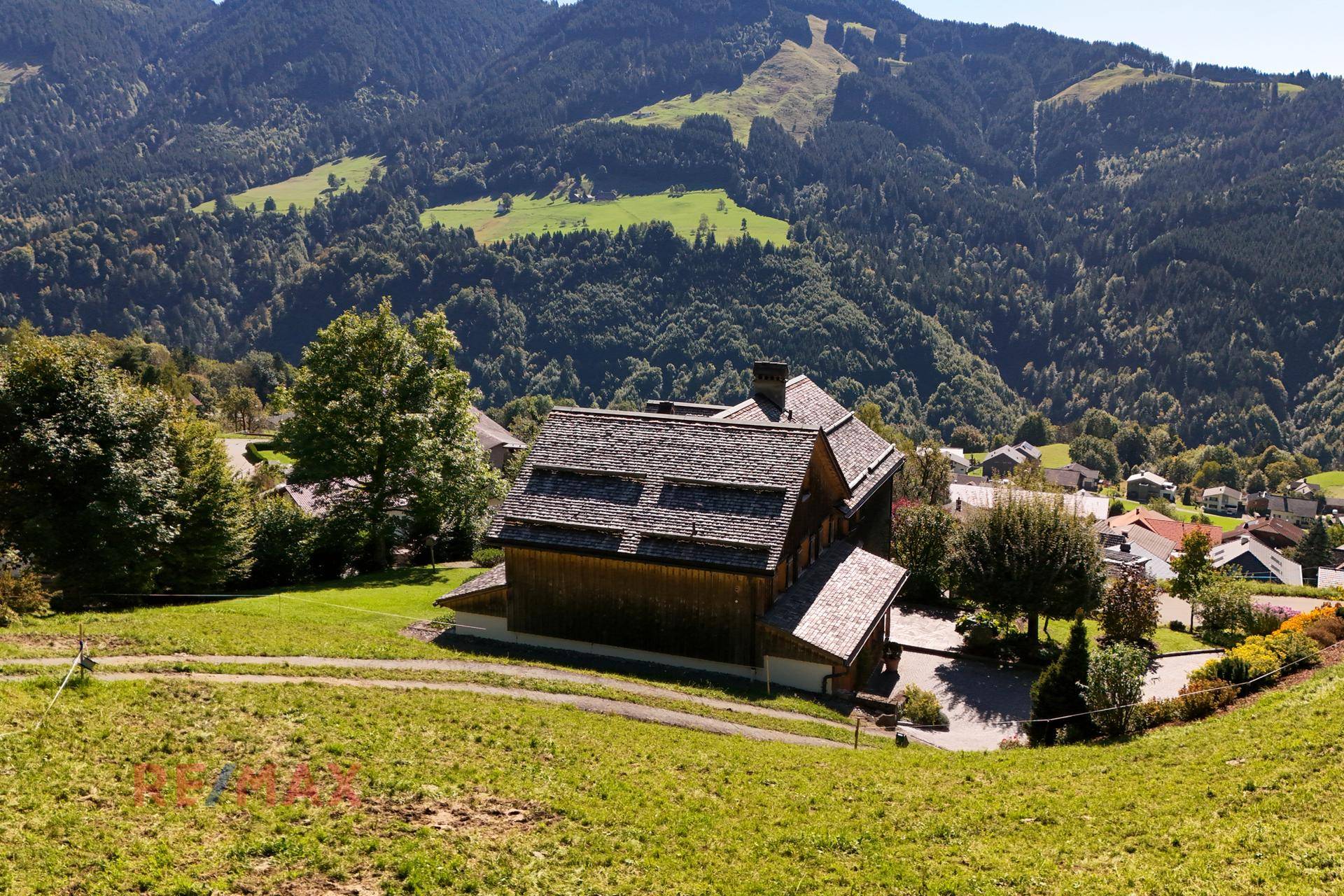 Panoramablick auf das traditionelle Holzhaus in einer idyllischen Berglandschaft.