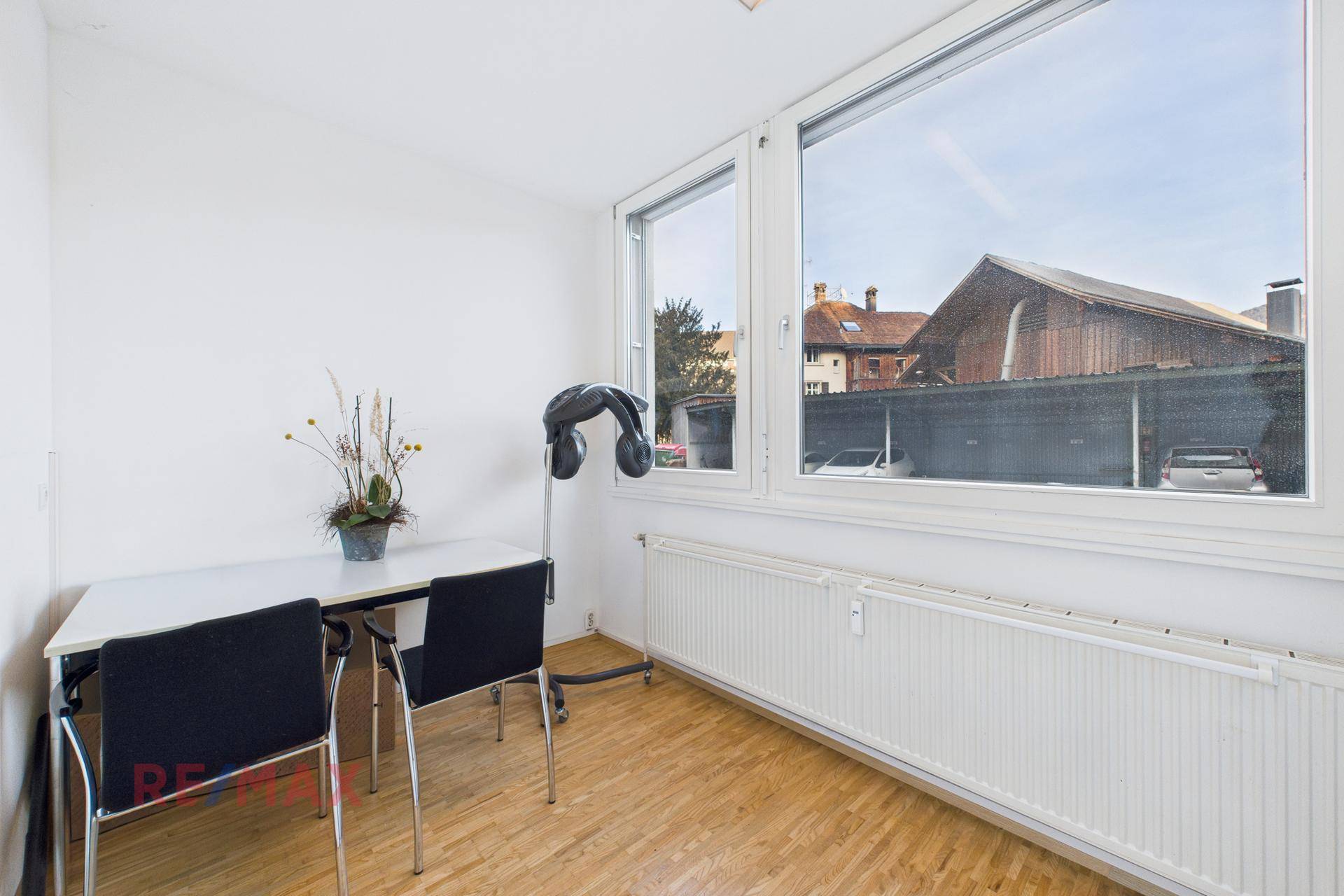 Kleiner Essbereich oder Pausenraum mit Tisch, Stühlen und großem Fenster.