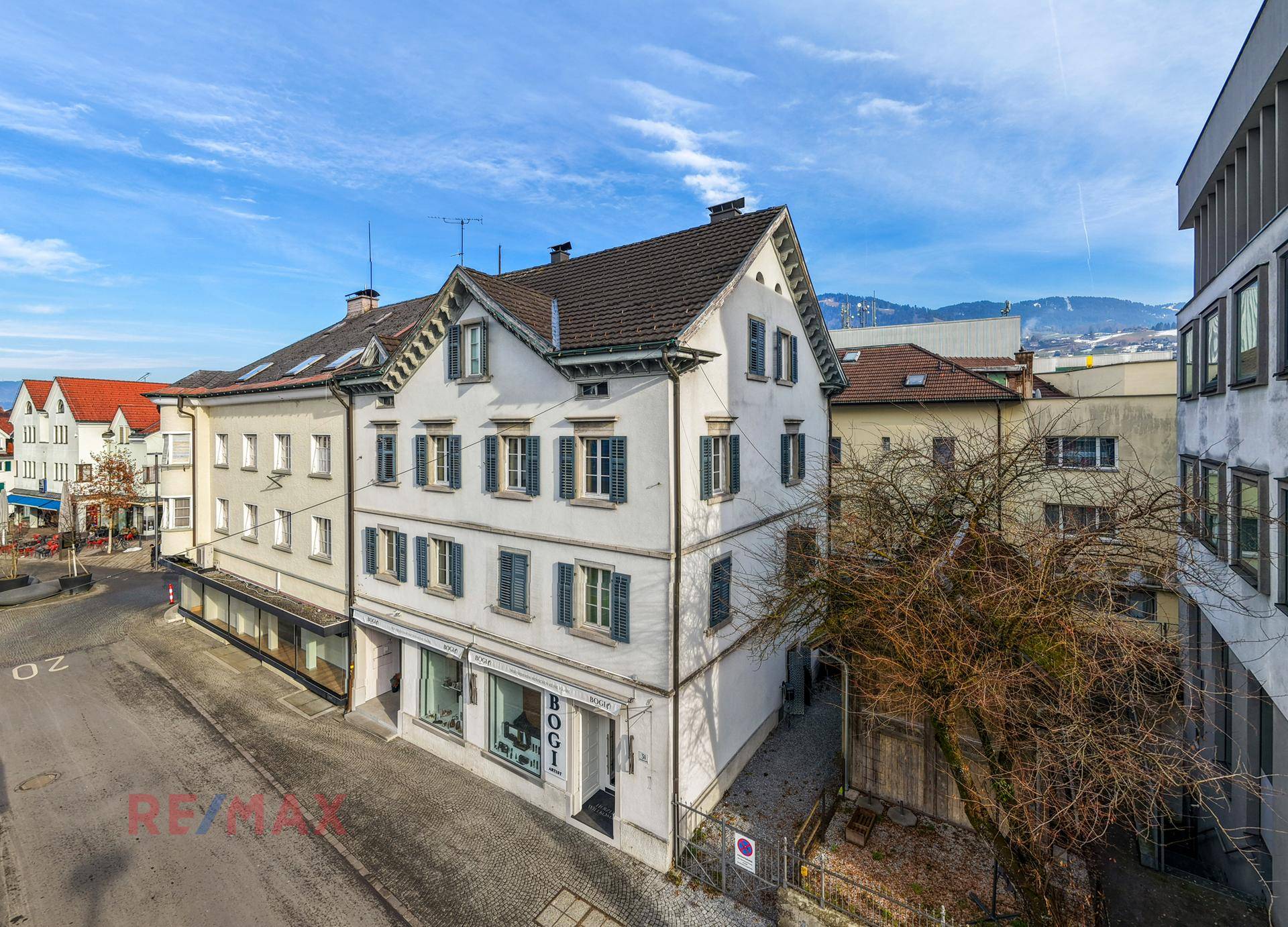 Historisches Gebäude in städtischer Umgebung mit Blick auf die umliegenden Berge und Dächer.