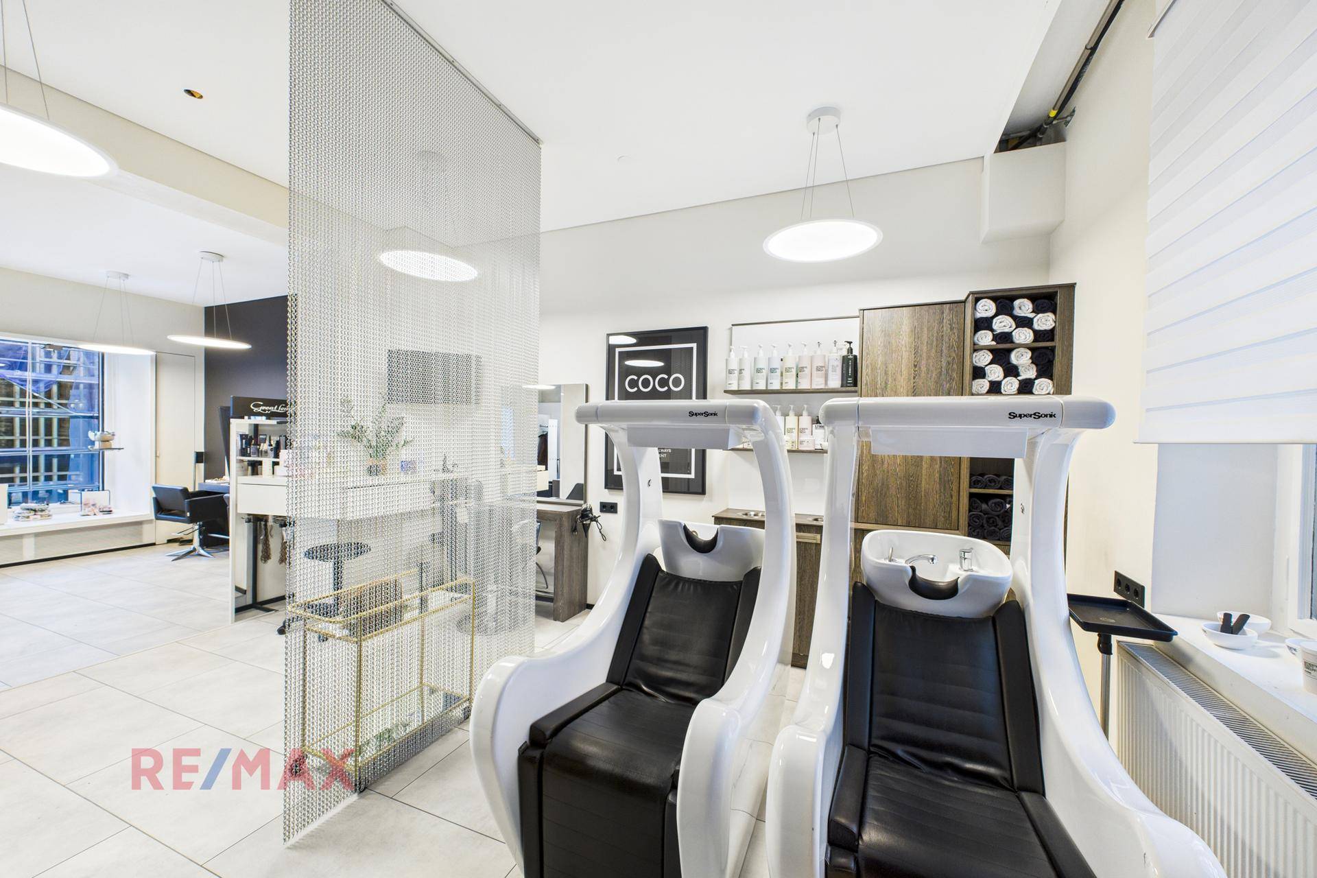 Professionelle Haarwaschstationen in einem modernen Salon mit heller Einrichtung und Fliesenboden.