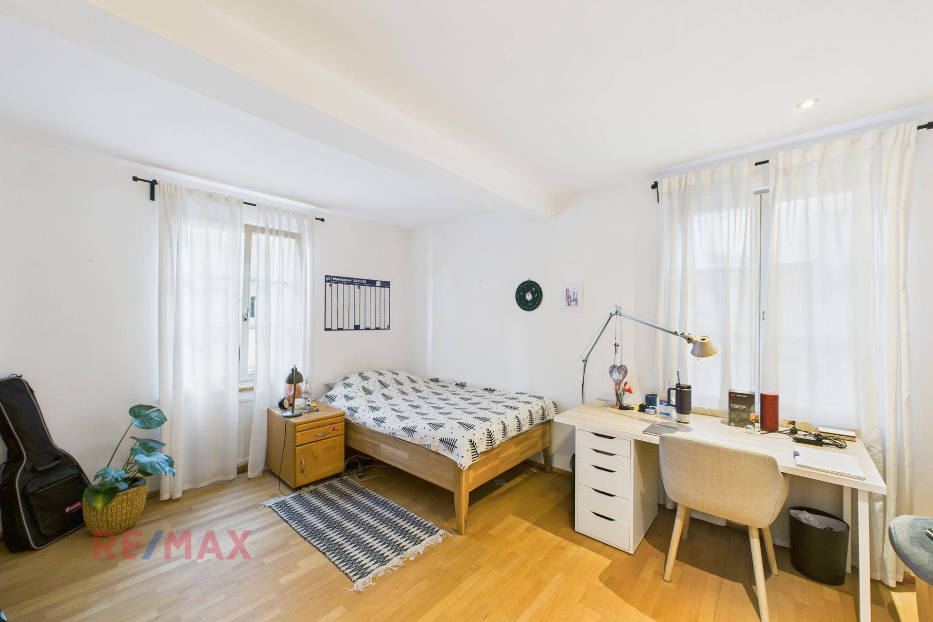 Helles Schlafzimmer mit Holzbett, Schreibtisch und Parkettboden, ideal für Studenten.