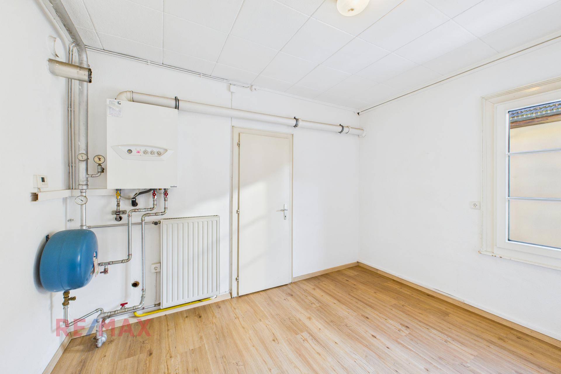 Technikraum mit Heizungsanlage, Rohren und Fenster, funktional und gut zugänglich.