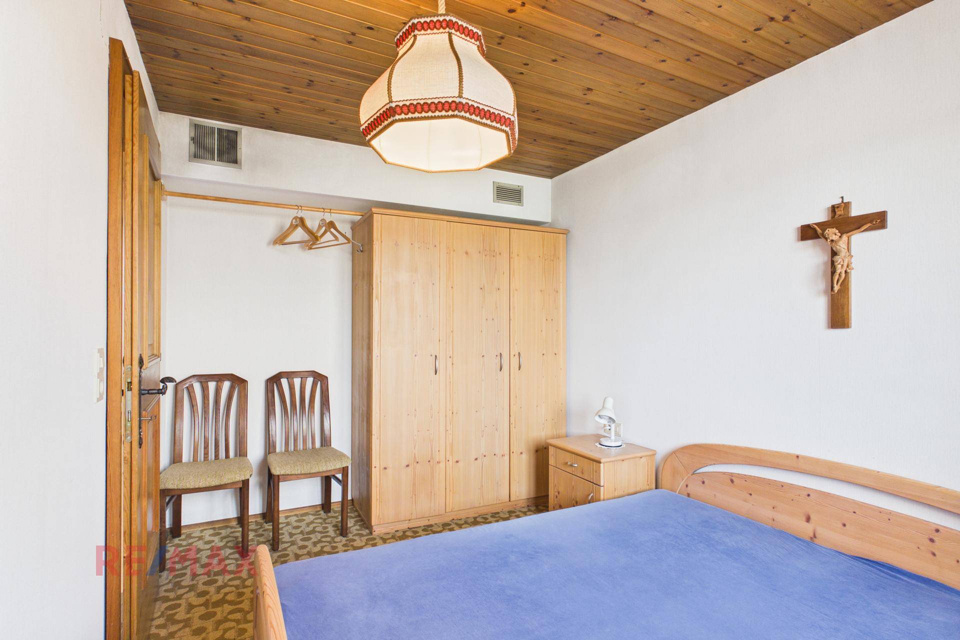 Schlafzimmer mit Doppelbett, Holzschrank und traditioneller Dekoration.