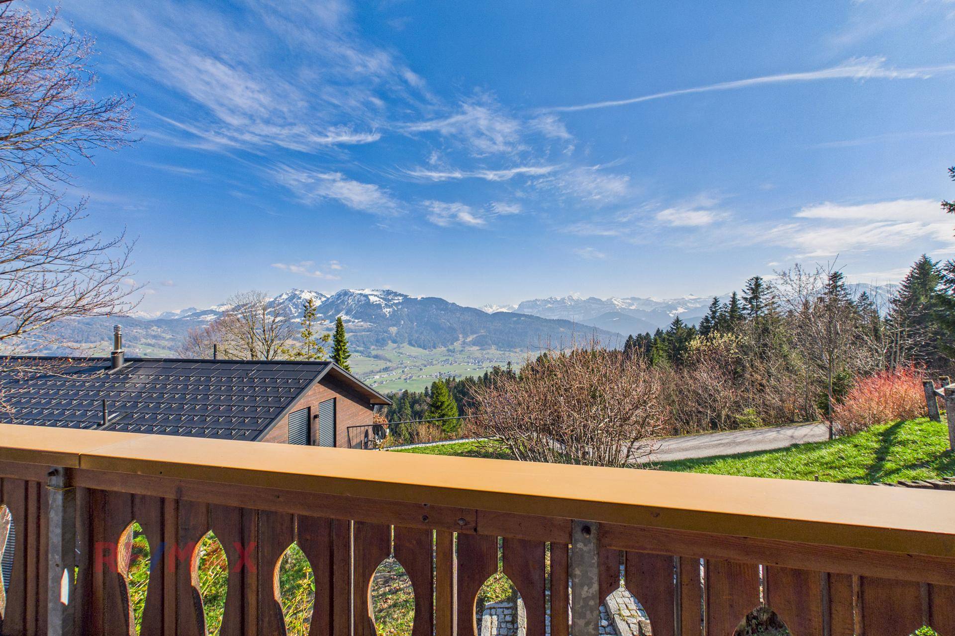 Atemberaubender Panoramablick vom Balkon auf die schneebedeckten Berge und grüne Täler.