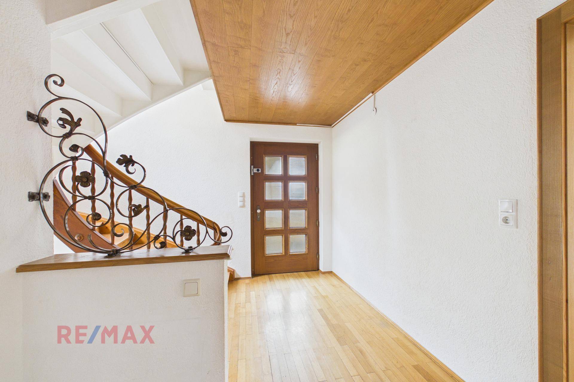 Geräumiger Flur mit Holzdecke, Parkettboden und Zugang zur Holztreppe.