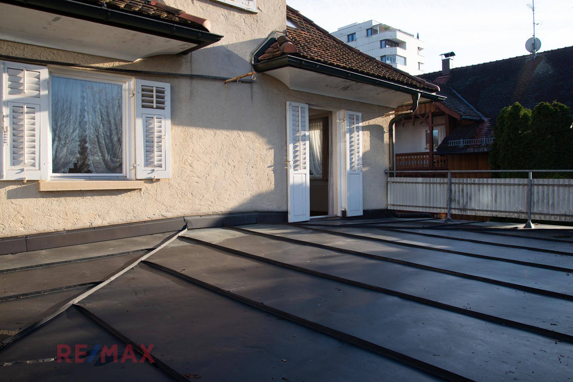 Weitläufige Dachterrasse mit Zugang vom Haus und Blick auf die Umgebung.