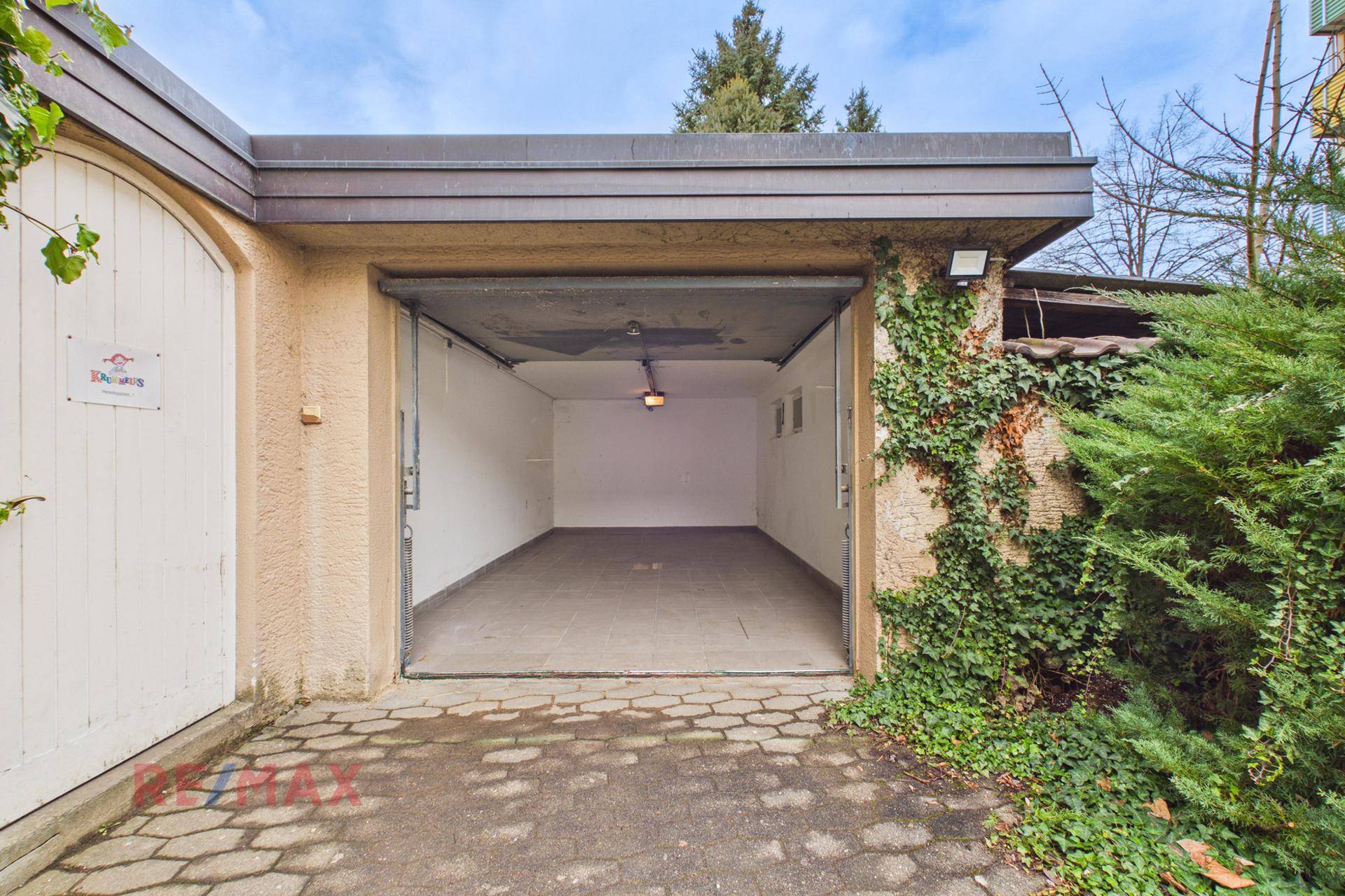 Offene Garage mit Platz für ein Fahrzeug und Zugang zur Einfahrt.