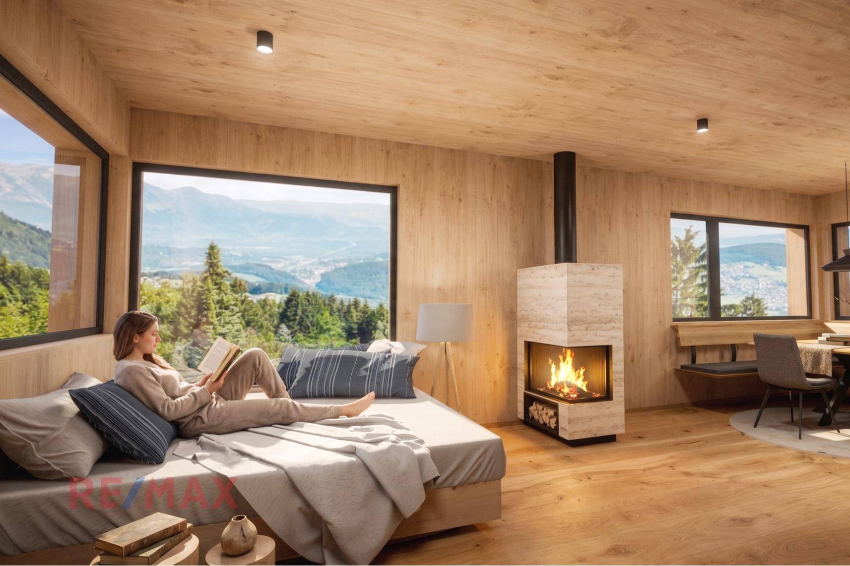 Helles Wohnzimmer mit großen Fenstern, Kamin und atemberaubendem Bergblick, ideal zum Entspannen.