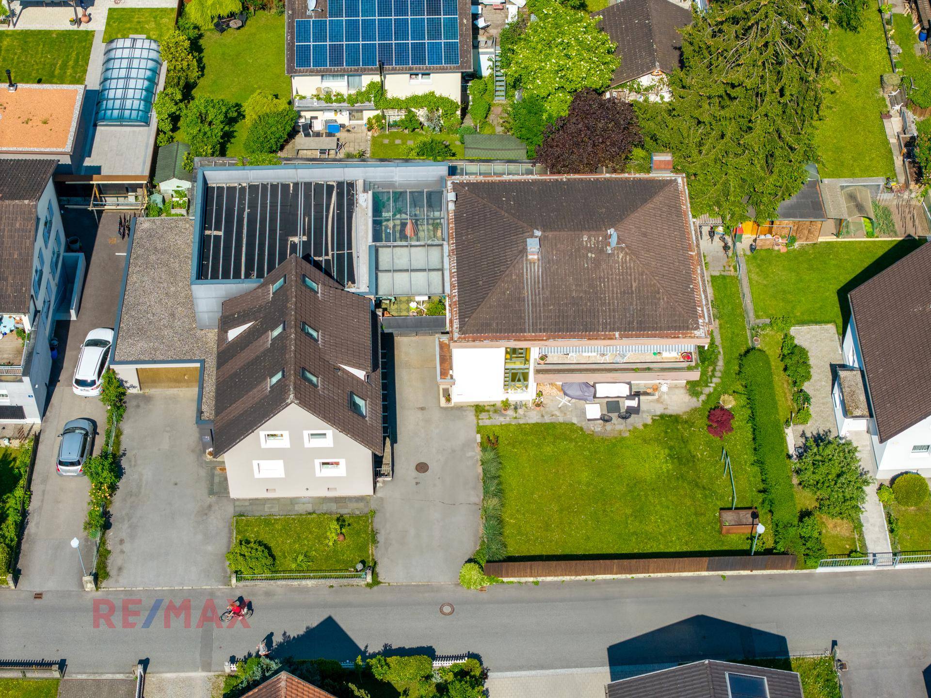 Weitläufige Luftaufnahme von zwei Wohnhäusern mit Gärten und angrenzenden Straßen in einer Wohnsiedlung.
