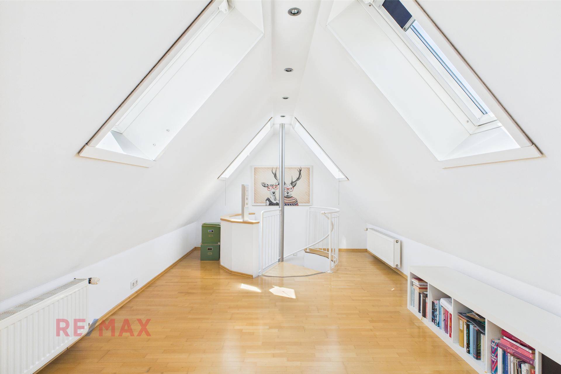 Helles Dachgeschoss-Schlafzimmer mit Holzboden, Wendeltreppe und Dachfenstern für viel Licht.