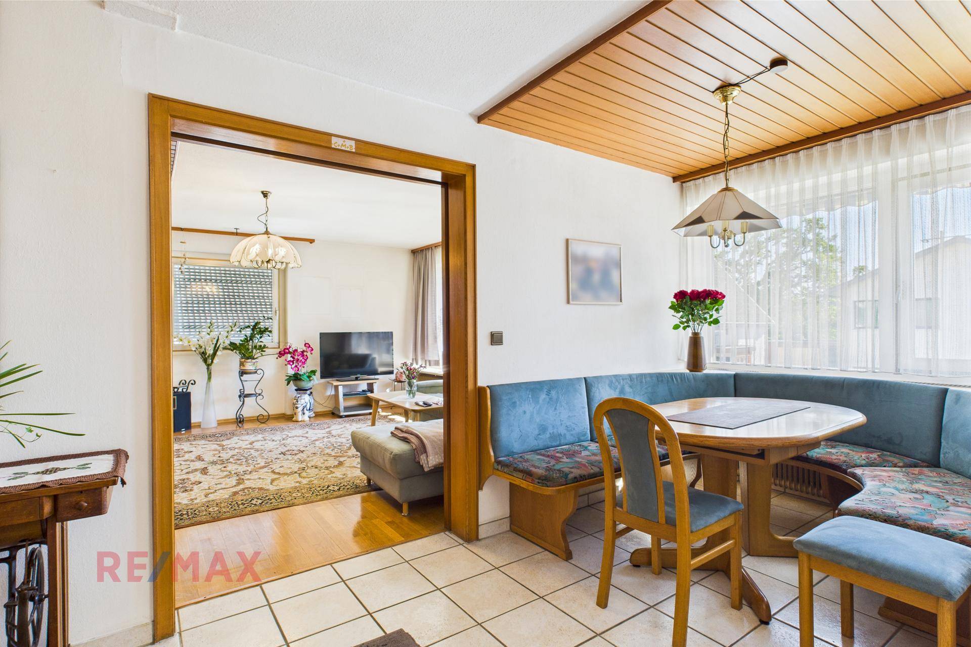 Essbereich mit Eckbank und Blick in das angrenzende Wohnzimmer mit Parkettboden.